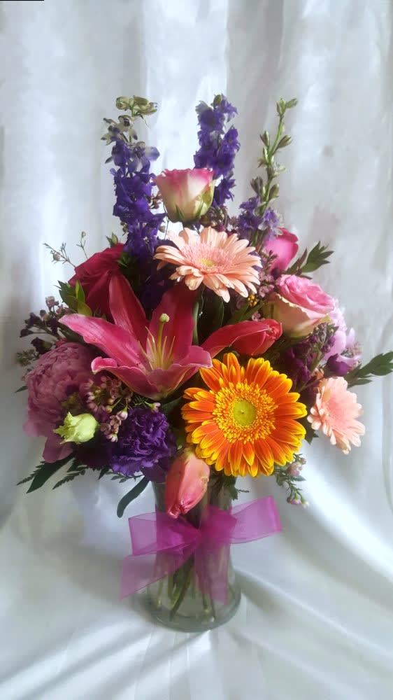 Mixed bouquet in a glass vase with pink, orange, and purple flowers