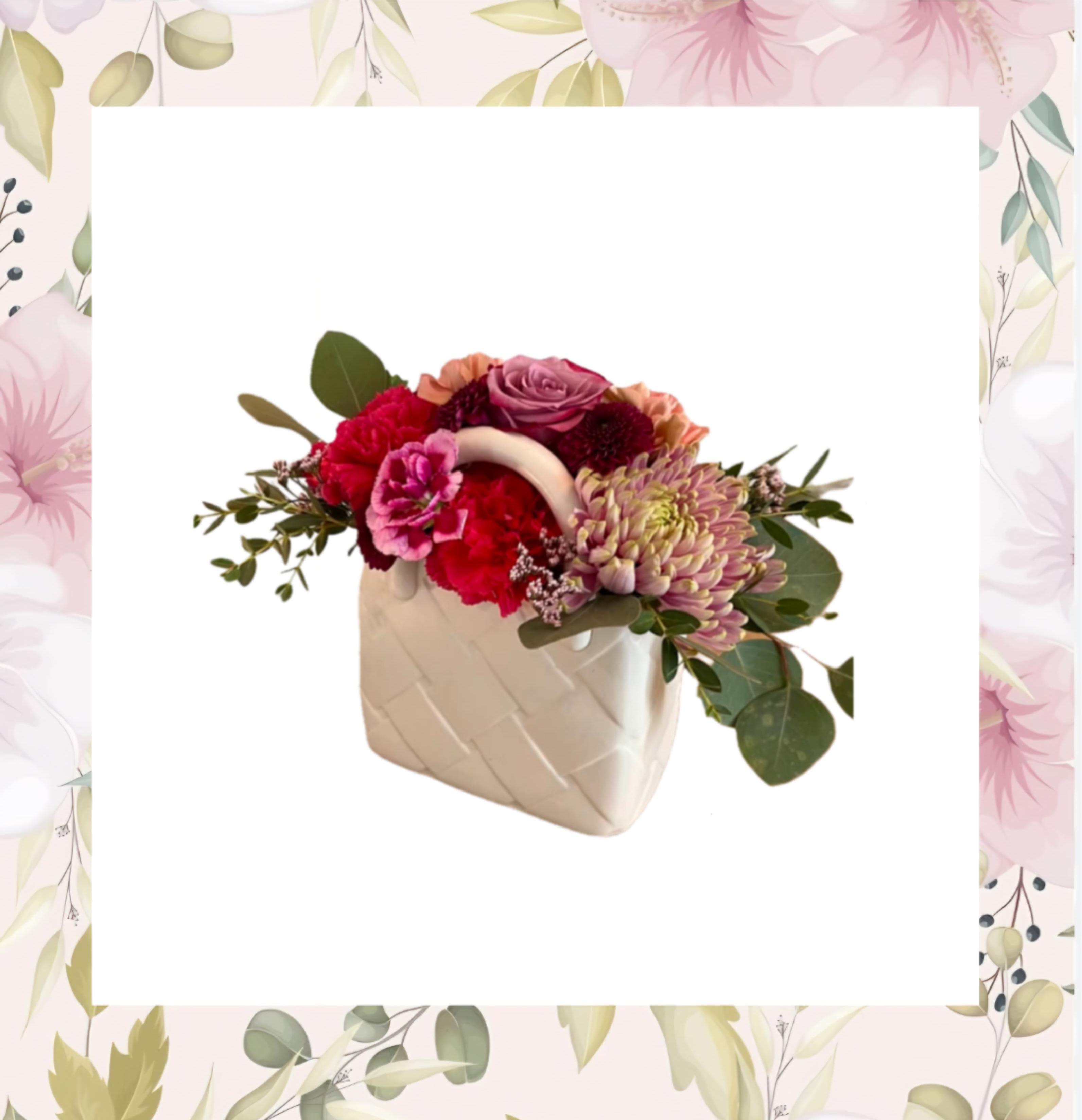 Pink and red flower arrangement in a white ceramic vase