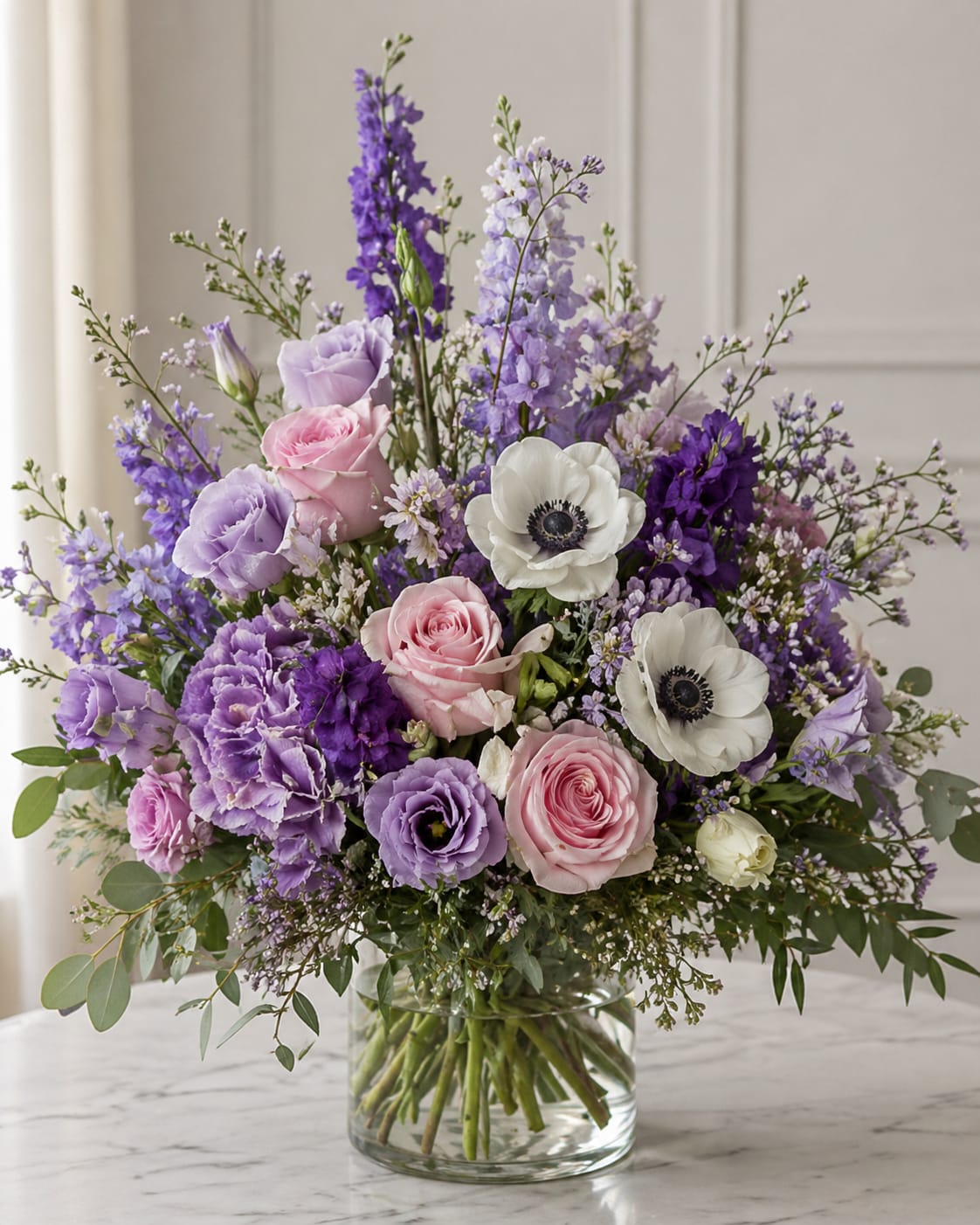 Lavender Meadow Garden - A soft, garden-inspired blend of lavender, blush, and ivory blooms featuring anemones, roses, and delicate larkspur for height and movement. Light, airy, and effortlessly elegant, this design brings a fresh-from-the-garden feel to any space. Please note, the final product will be an inspiration of this photo. 