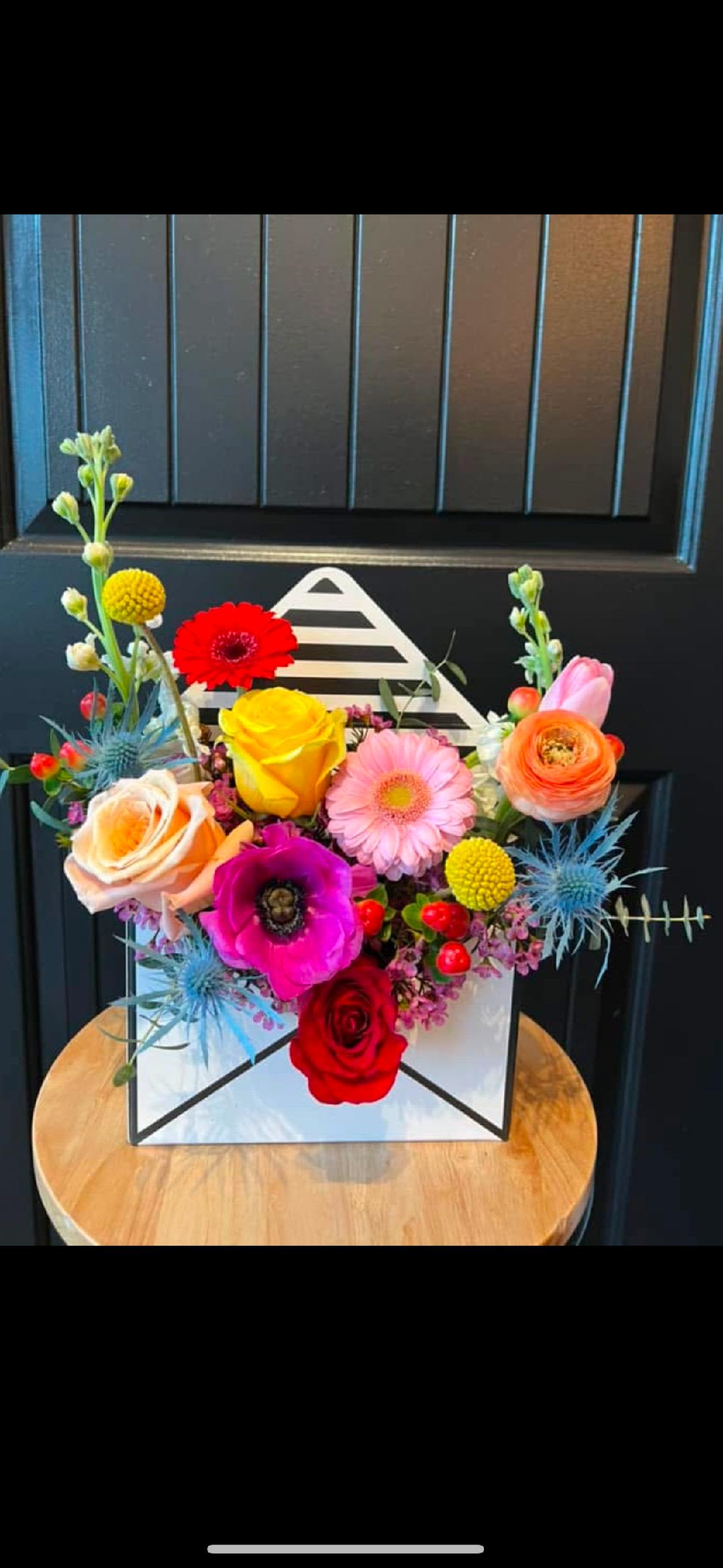 Colorful mixed flower arrangement in a white box with roses and gerbera daisies