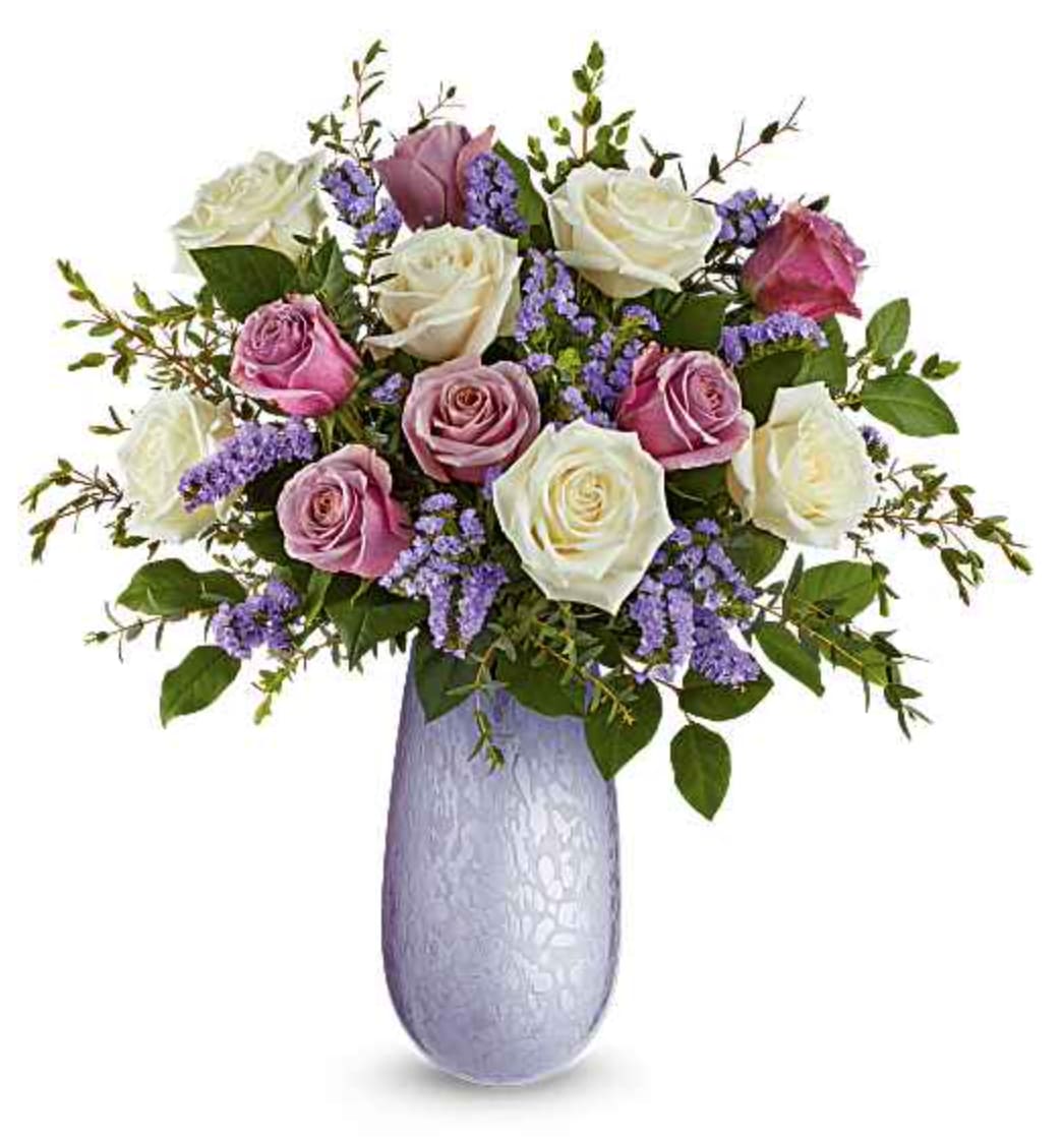 Marvelous Moments Bouquet - Our Marvelous Moments Bouquet features crème roses, lavender roses, lavender sinuata statice, parvifolia eucalyptus, and salal. Arranged in a hand-blown iridescent Vivi vase, this elegant all-rose bouquet is a timeless expression of love and romance. Orientation: All-Around  SUBSTITUTION POLICY – Always deliver the freshest flowers! Please note the bouquet pictured reflects our original design.  If the exact flowers or container in this arrangement are not available, our local florists will create a beautiful bouquet with the freshest available flowers.