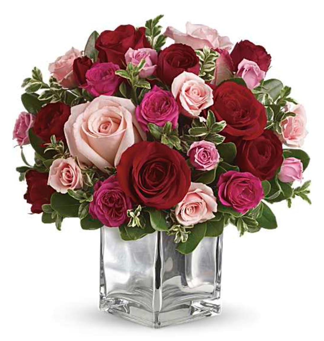 Love Medley Bouquet with Red Roses - Sing them a love song - with flowers. This lush, loving rose arrangement tells them just how much you care. The stylish bouquet features large red and pink roses accented with smaller spray roses in shades of red and pinks. Delicate green oregonia and pittosporum add a fresh contrast. The flowers are delivered in our exclusive Mirrored Silver Cube vase. Orientation: All-Around  SUBSTITUTION POLICY – Always deliver the freshest flowers! Please note the bouquet pictured reflects our original design.  If the exact flowers or container in this arrangement are not available, our local florists will create a beautiful bouquet with the freshest available flowers. 