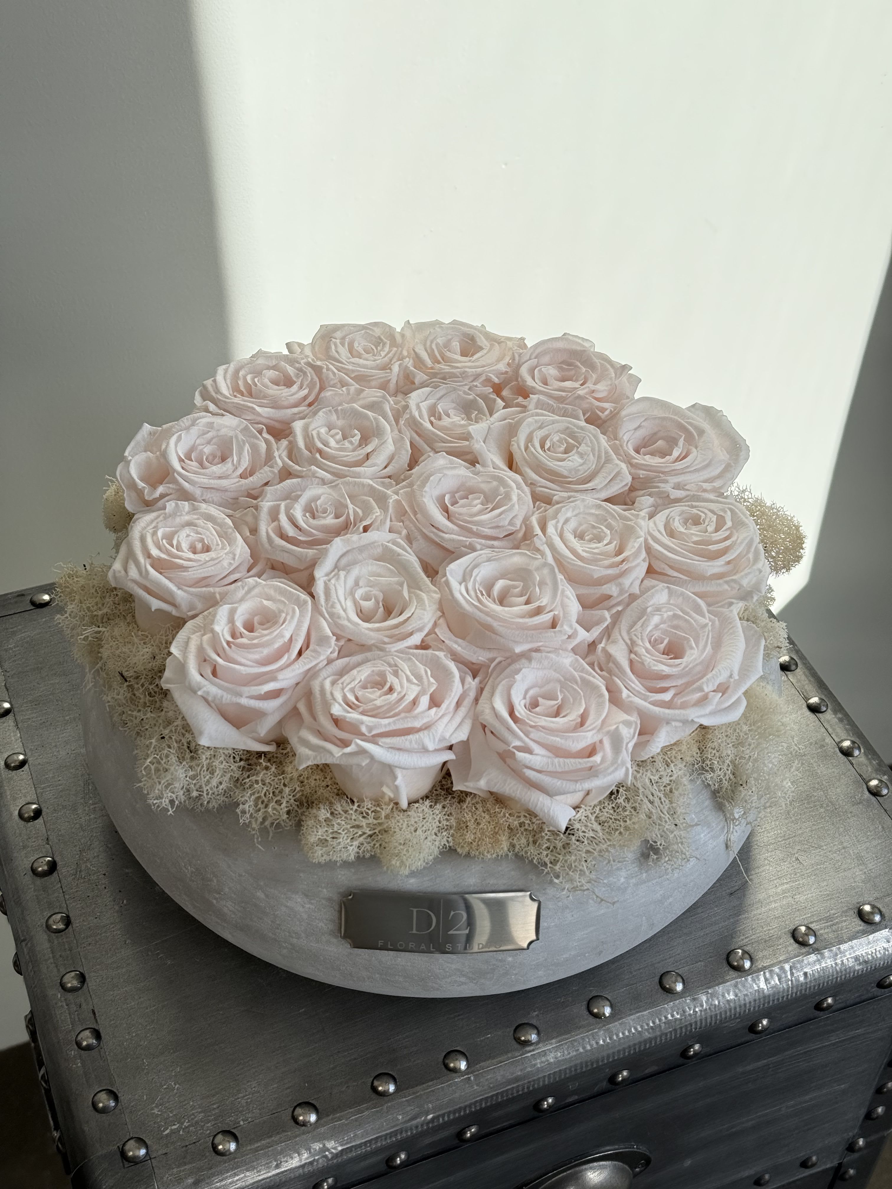 Round arrangement of pale pink roses in a silver box