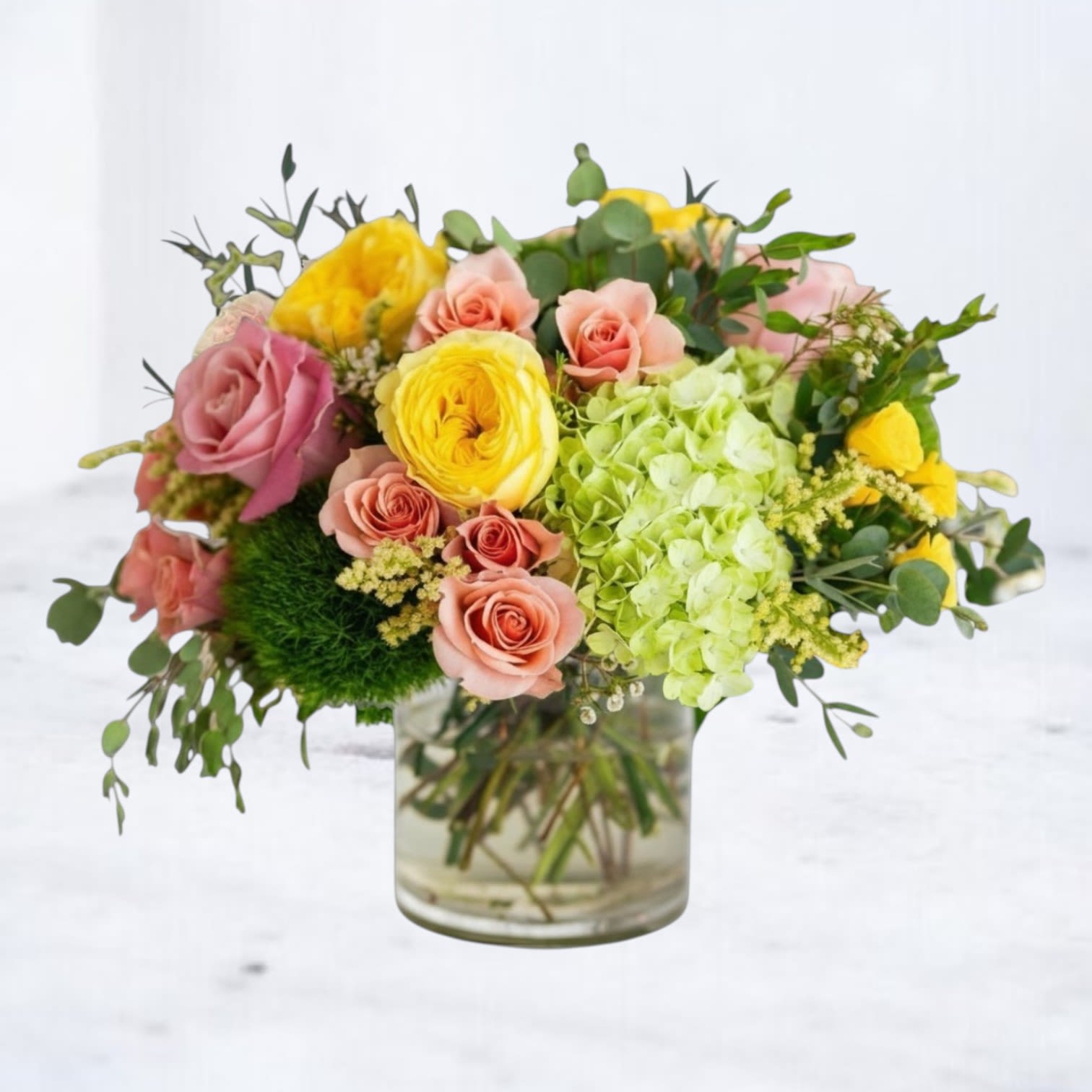 Fresh Press - Fresh Press is a bright, modern flower arrangement designed with peach roses, yellow ranunculus, lime green hydrangea, seasonal blooms, and fresh textural greenery in an airy garden-style composition. Designed in a clear glass vase, this arrangement blends citrus-inspired tones with soft blush accents for a look that feels vibrant, artistic, and effortlessly fresh.  Perfect for birthdays, celebrations, thank you gifts, get well flowers, or everyday flower delivery, Fresh Press brings together premium seasonal flowers in a playful yet refined design style. Its clean palette of yellow, green, peach, and blush makes it a standout arrangement for anyone who loves modern flowers with natural movement and color.  Available for same-day flower delivery in Magnolia, TX and surrounding areas including The Woodlands, Montgomery, Conroe, Spring, Tomball, and nearby Lake Conroe communities.
