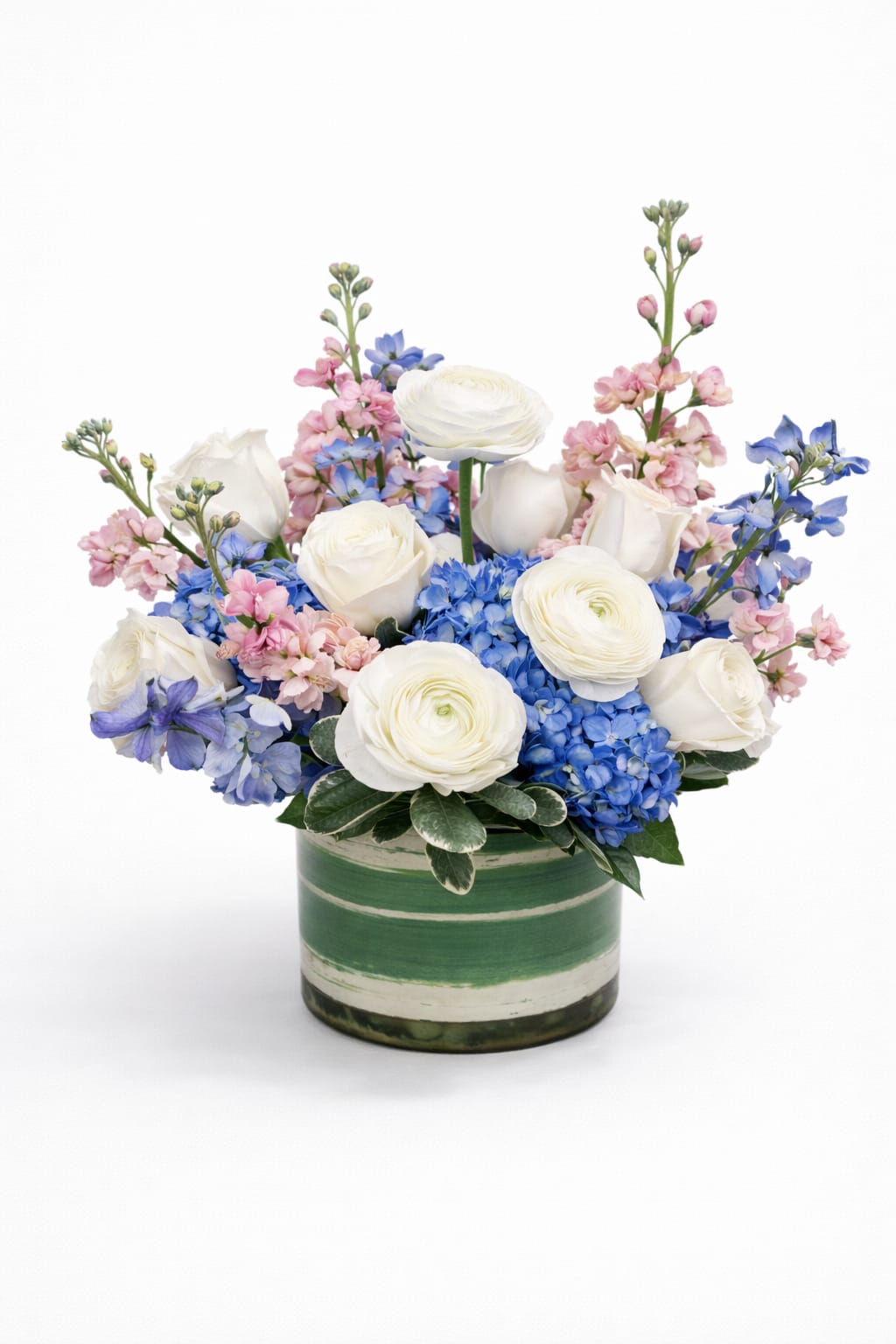 White roses and blue hydrangeas in a green striped vase