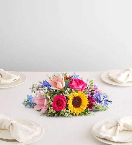 Painter’s Garden Flower  -  Pet Friendly? No This arrangement contains lilies, which are highly toxic to cats, and eucalyptus, which is toxic to both cats and dogs. Keep out of reach; avoid homes with curious cats.    Human Allergy Note This arrangement contains several high-pollen flowers including sunflowers, lilies, and daisies. Keep away from bedside tables and ensure the room is well-ventilated to minimize irritation.   Care &amp; Longevity As this is a centerpiece in a shallow container, check the water level daily as it may evaporate quickly. Gently add fresh water to the center of the container, avoiding the blooms. Remove fading petals to keep the arrangement fresh, and keep it away from direct sunlight or heating vents.    Best Occasions &amp; Situations  Vibrant Birthday surprise  Dinner party celebration  Housewarming gift  Get well encouragement ️ Just because cheer  Why Customers Love It Lush and full appearance from every angle. Low-profile height makes it perfect for seated dinner parties. Bold primary colors that stand out in any room. Long-lasting variety of blooms and textures.