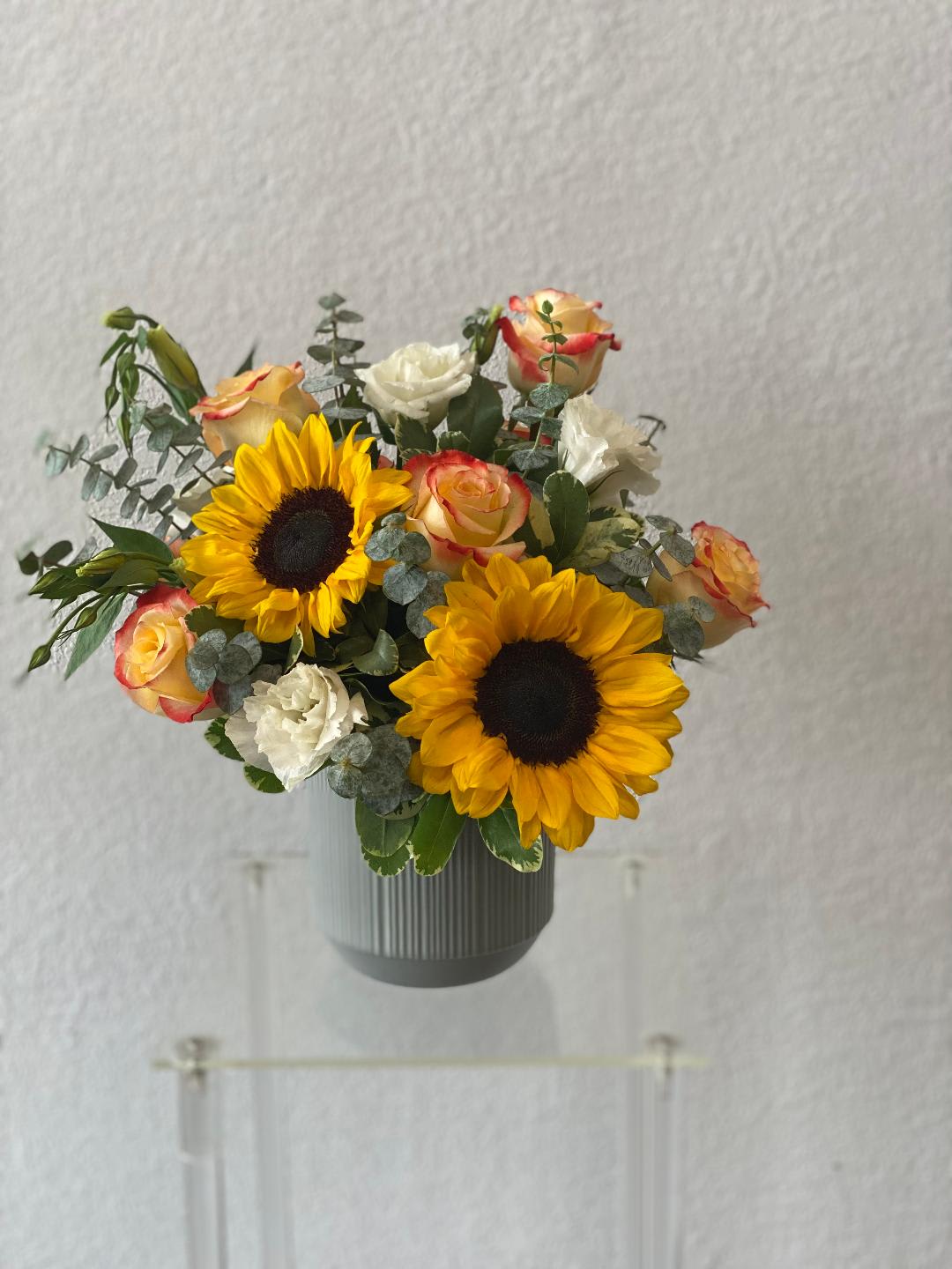 Sunflower and rose bouquet in a gray vase