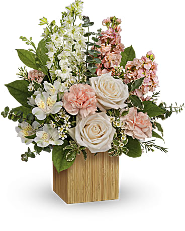Pink and white floral arrangement in a wooden cube vase