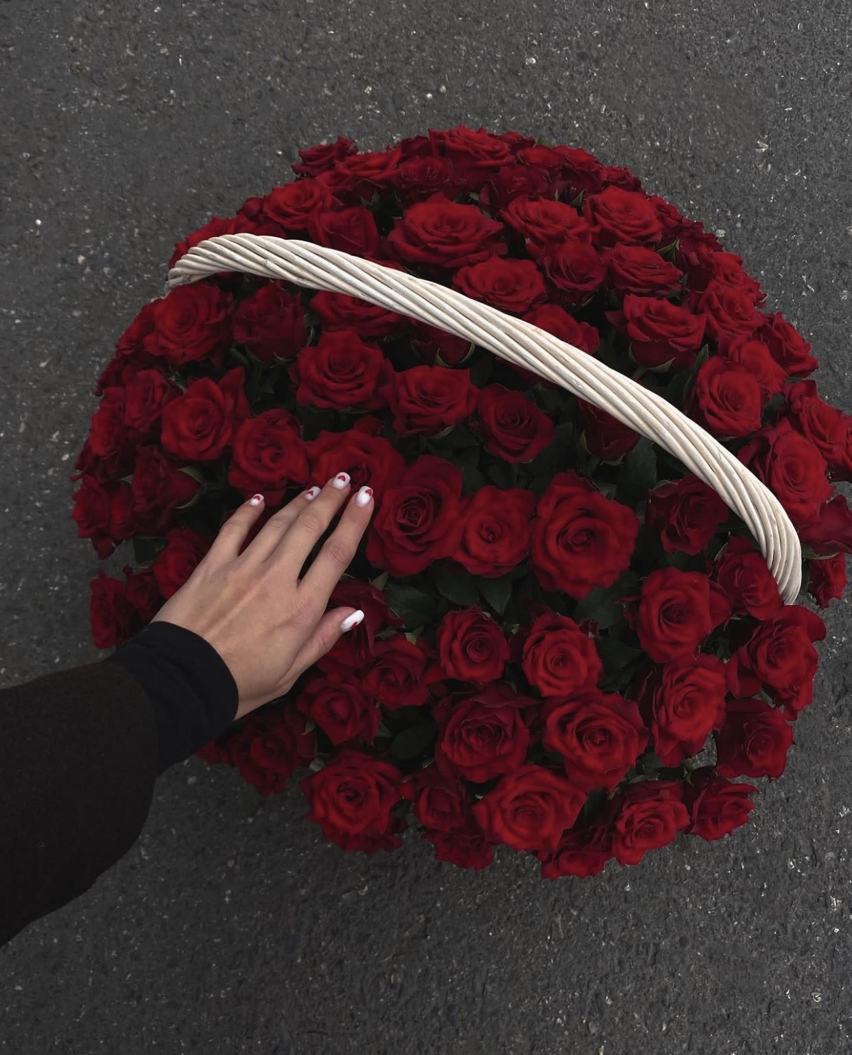 Basket filled with red roses and a white handle