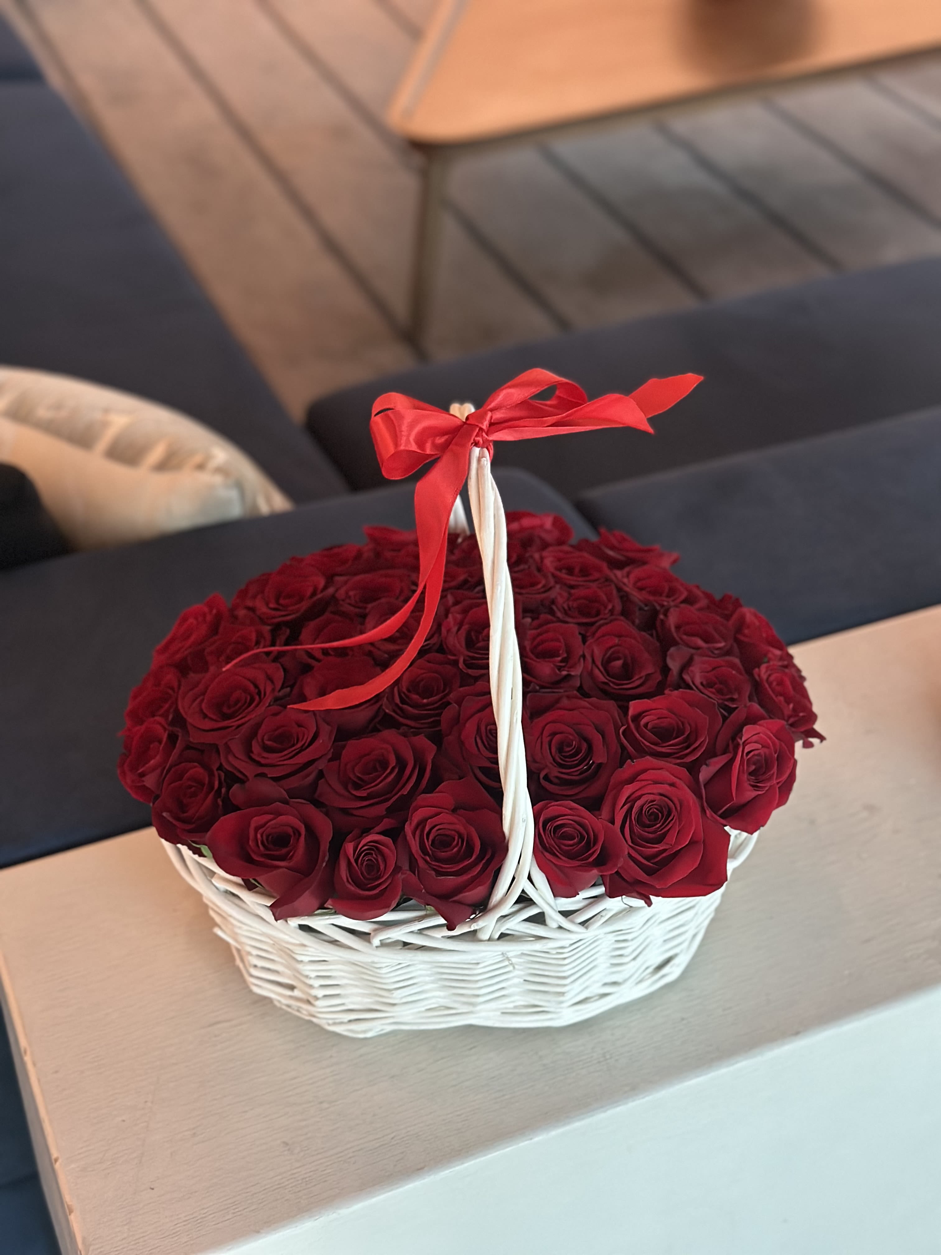 Basket of red roses tied with a red ribbon