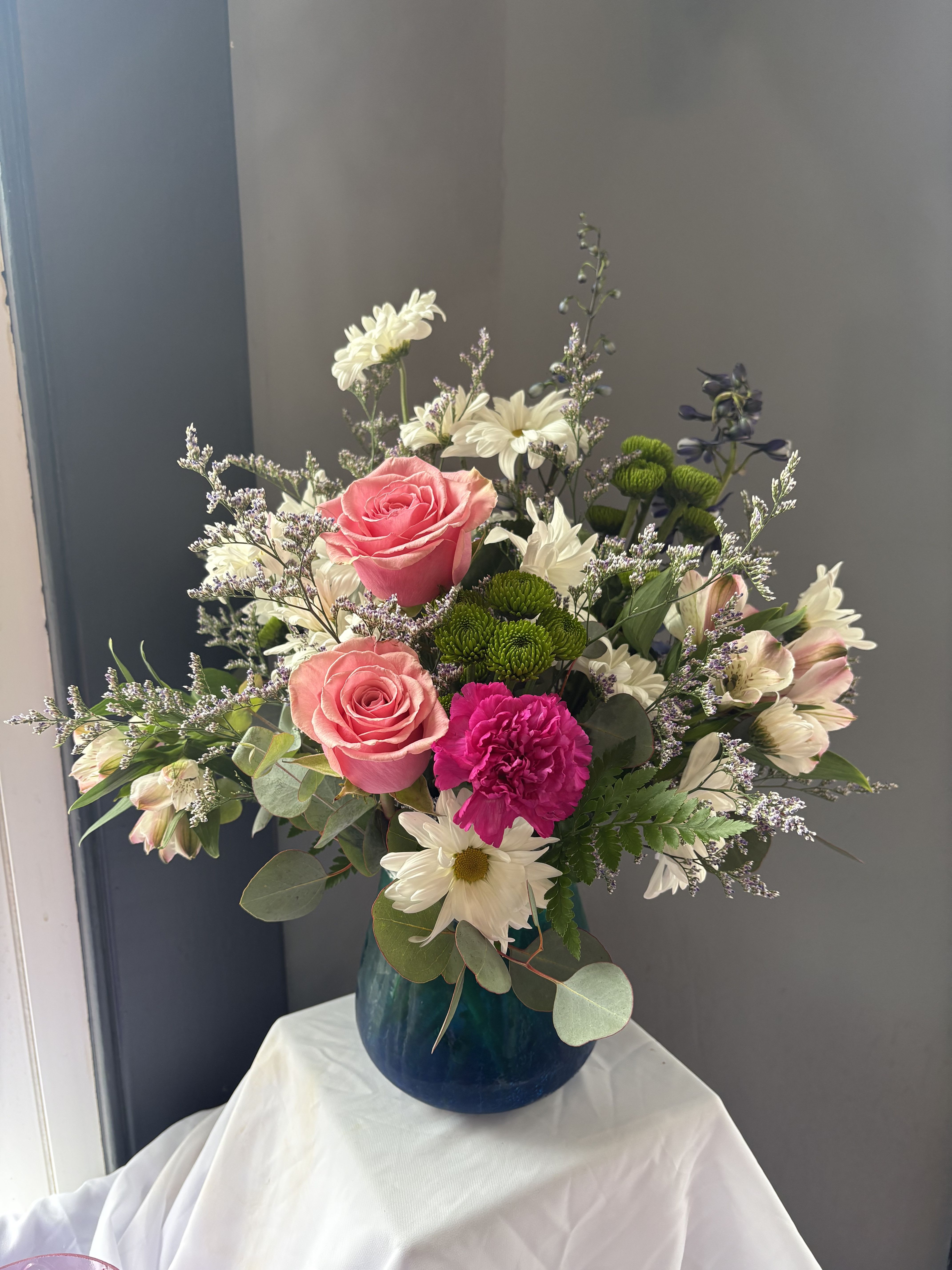 Frazier's Version Blue Hues Bouquet - Frazier's Version Blue Hues Bouquet delights with blush pink blooms and airy whites, artistically arranged in a translucent turquoise glass vase with a crackled finish and dreamy gradient. A beautiful way to share calm and joy.