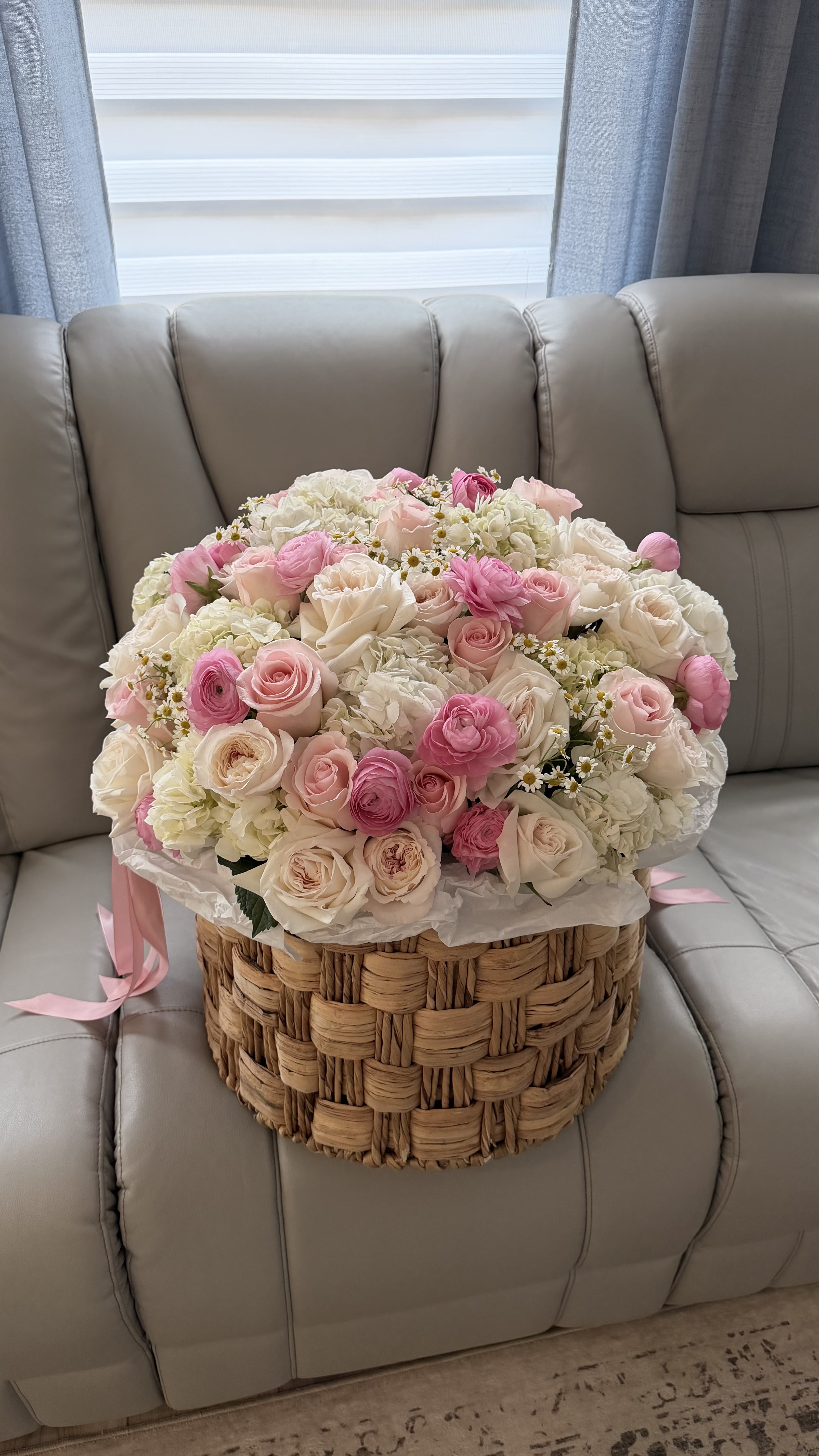 Blush Cottage Basket - A soft, storybook-inspired arrangement that feels like a gentle morning in a blooming garden. Blush Cottage Basket features a romantic blend of premium roses, spray roses, hydrangea, ranunculus, and delicate chamomile accents in shades of blush pink, creamy ivory, and soft white.