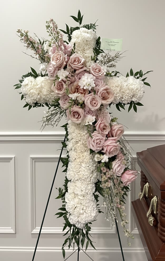 White and Pink Cross - Large standing cross of white blooms with blush-pink roses, lush greenery on an easel.