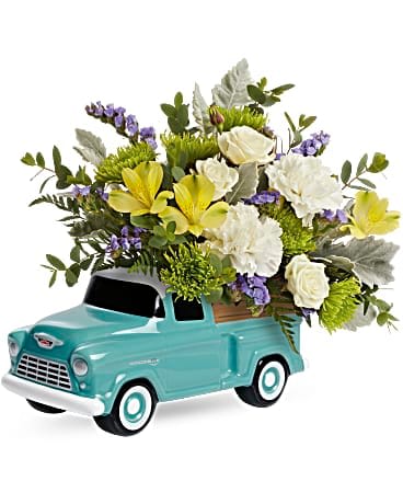 Flower arrangement in a turquoise toy pickup truck