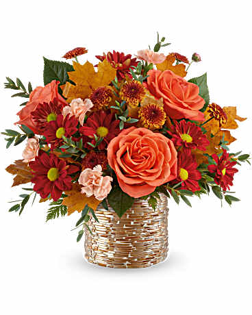 Orange roses and red daisies in a woven basket