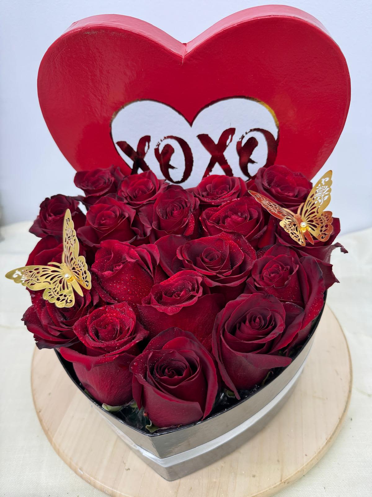 Heart-shaped box of red roses with butterfly decorations