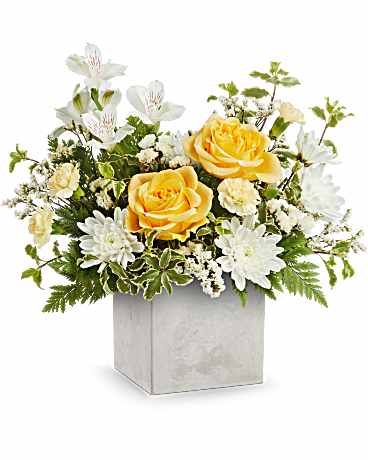 Yellow roses and white daisies in a square white vase