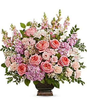 Pink roses and mixed pastel flowers arranged in a dark urn vase