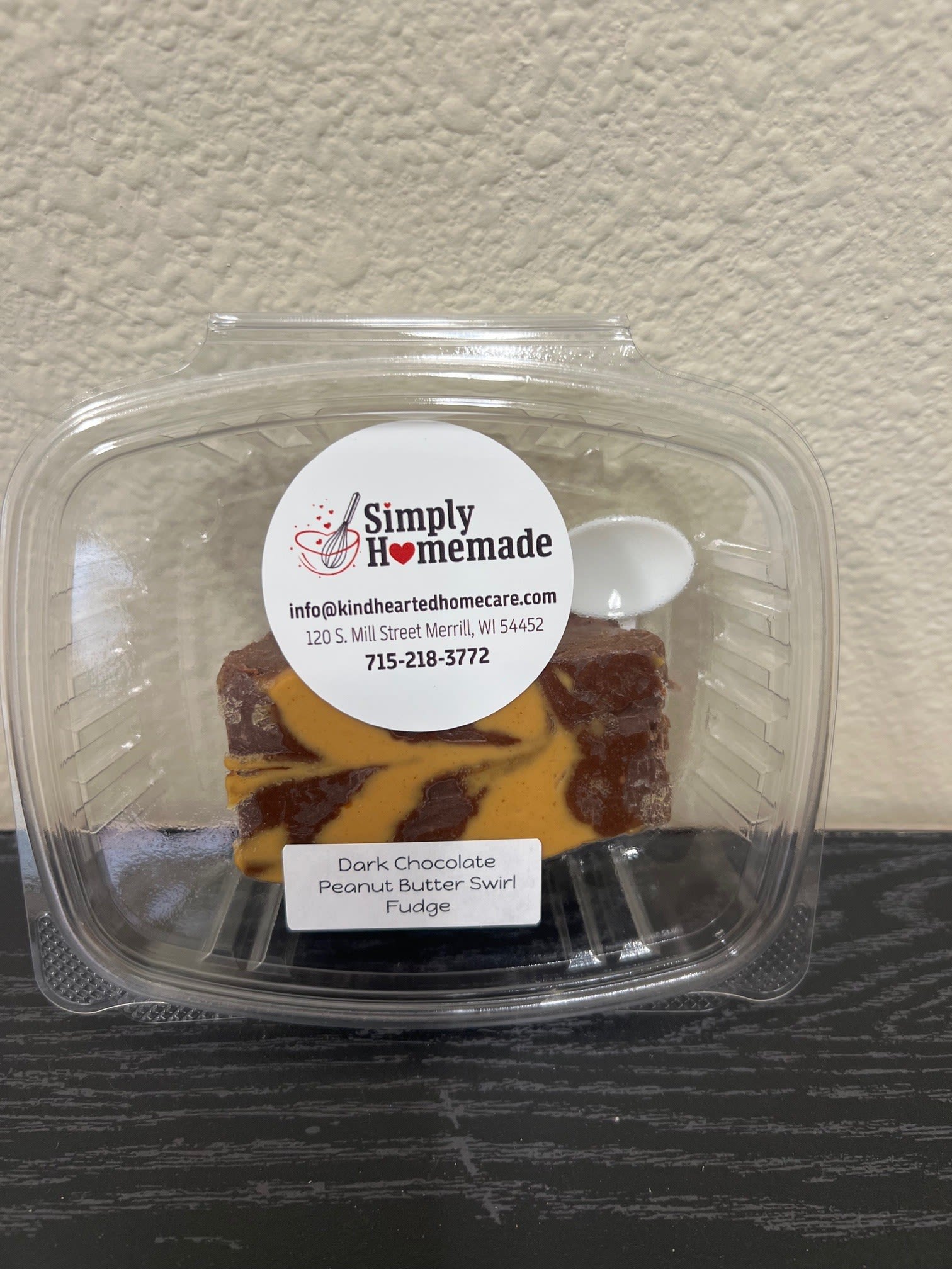 Plastic clamshell container holding dark chocolate peanut butter swirl fudge