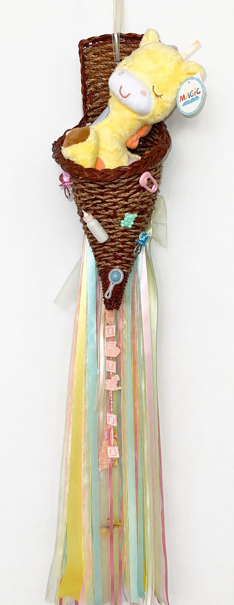 Wicker cone with a plush yellow giraffe and pastel ribbons