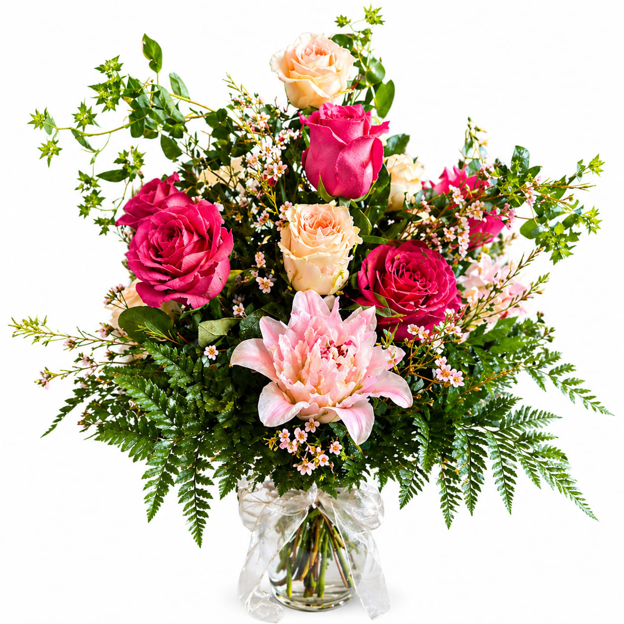 Garden Elegance - Bright hot-pink and peach roses circling a pale pink lily give this garden-style arrangement an immediate, joyful presence - perfect as a birthday bouquet, anniversary flowers, or a thoughtful just-because gift. The color story of pink, peach, white, and green reads romantic and cheerful, so the person you're sending it to will feel both celebrated and genuinely seen the moment it arrives.  A loose, airy design mixes roses, a large pale pink lily, and delicate filler blossoms with long, branching greenery for a natural, freshly-cut look. It arrives in a clear glass vase tied with a sheer ribbon for a soft, polished finish; the shape is full yet garden-like, letting stems breathe and display texture and movement.  Choose this arrangement to mark birthdays, anniversaries, or to brighten someone's day - it says affection without fuss. Standard care: keep water fresh, recut stems every few days, and place out of direct sun or heat to enjoy the blooms longer.