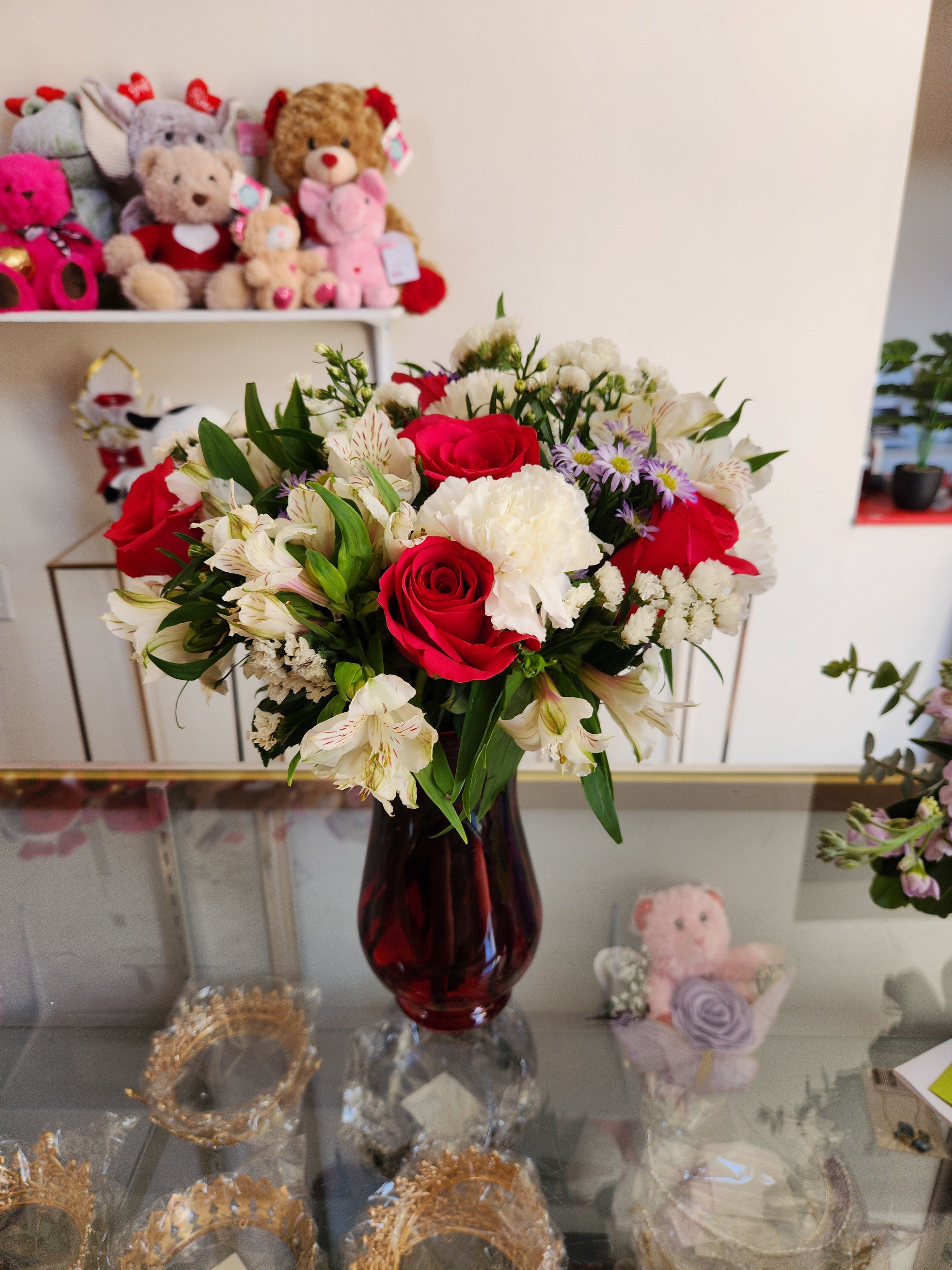 Bouquet of red roses and white flowers in a dark glass vase