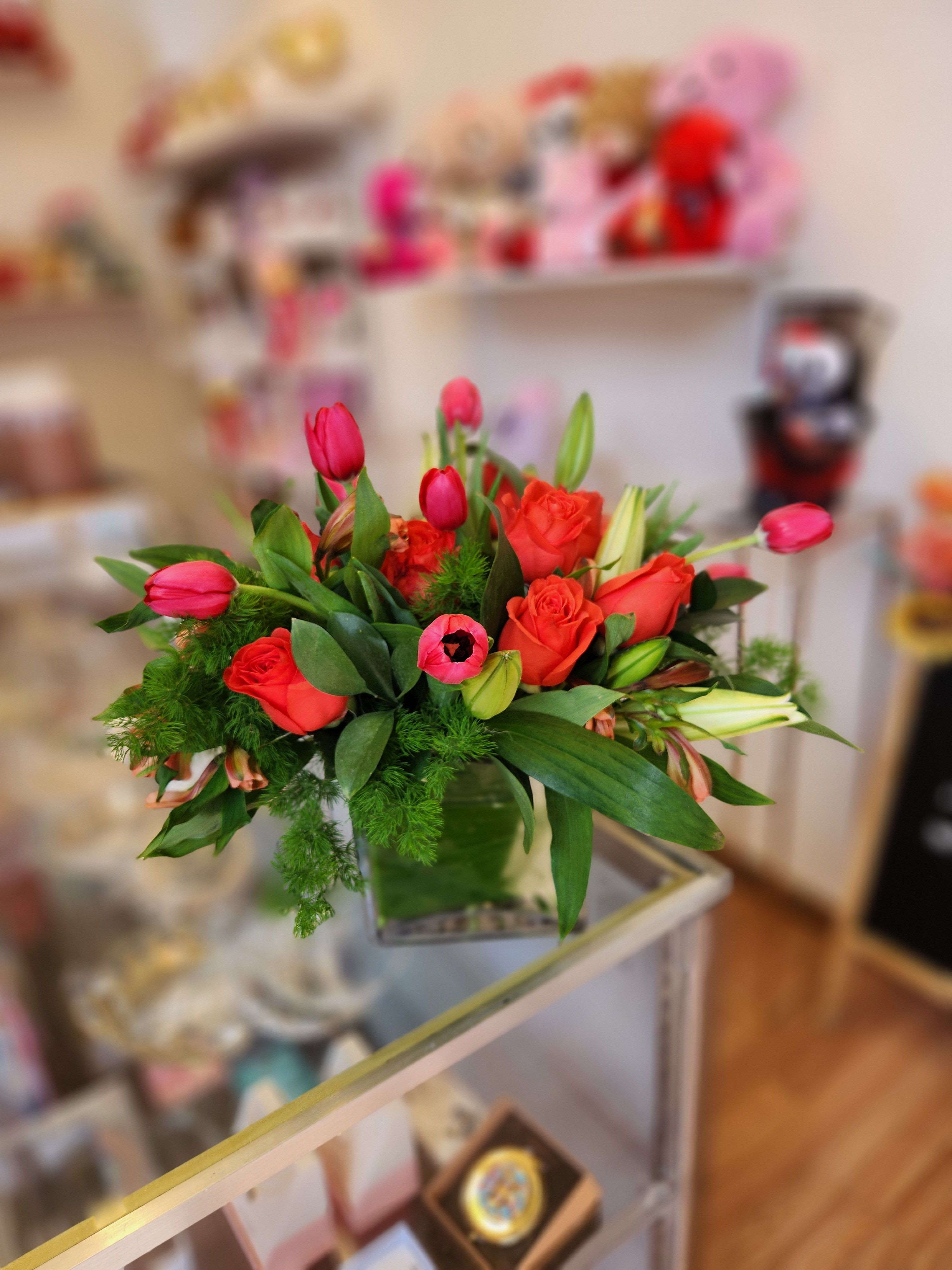 Bouquet of red roses and pink tulips in a glass vase