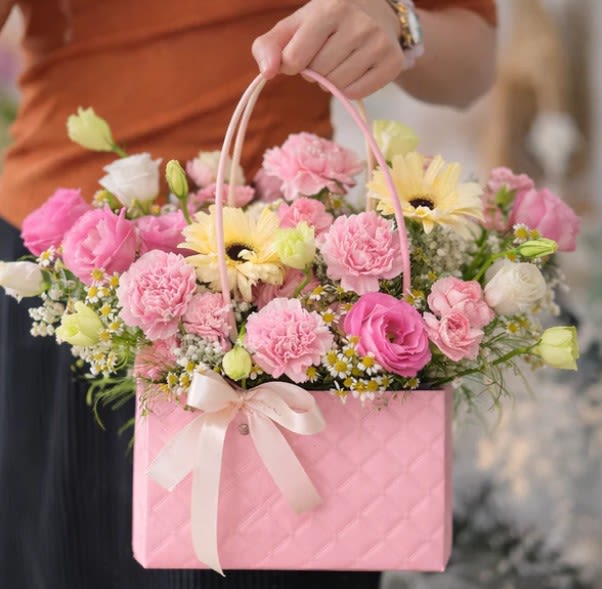 Spring Tote - Celebrate the beauty of spring with our Spring Flowers Mix, a stunning arrangement of fresh blooms in soft pink and pastel tones, beautifully presented in an elegant reusable pink tote. This charming bouquet captures the essence of spring's renewal and joy.    Perfect for: Mother's Day, birthdays, spring celebrations, thank you gifts, get well wishes, congratulations, or simply to brighten someone's day with the fresh beauty of spring.  Each Spring Flowers Mix arrangement is custom-designed with the freshest seasonal blooms to create a memorable gift that combines elegance, quality, and the vibrant spirit of spring. The reusable designer tote adds lasting value long after the flowers have been enjoyed.