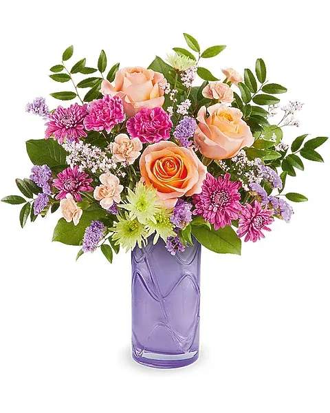 PRETTY DAYDREAM BOUQUET - Celebrate her sweetest moments with the Pretty Daydream Bouquet, a dreamy mix of soft, vibrant blooms beautifully arranged in the Pretty Daydream Vase-a charming keepsake she'll enjoy long after Mother's Day. The Pretty Daydream Bouquet features peach roses, fuchsia carnations, miniature peach carnations, green and purple cushion spray chrysanthemums, purple sinuata statice, and pink limonium, accented with huckleberry and salal, delivered in the Pretty Daydream Vase.  