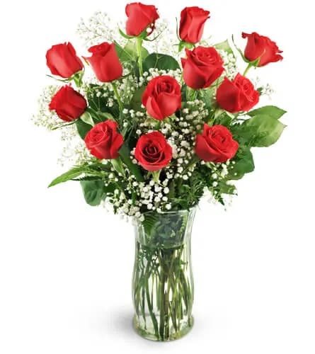 Red roses arranged in a clear glass vase with baby's breath