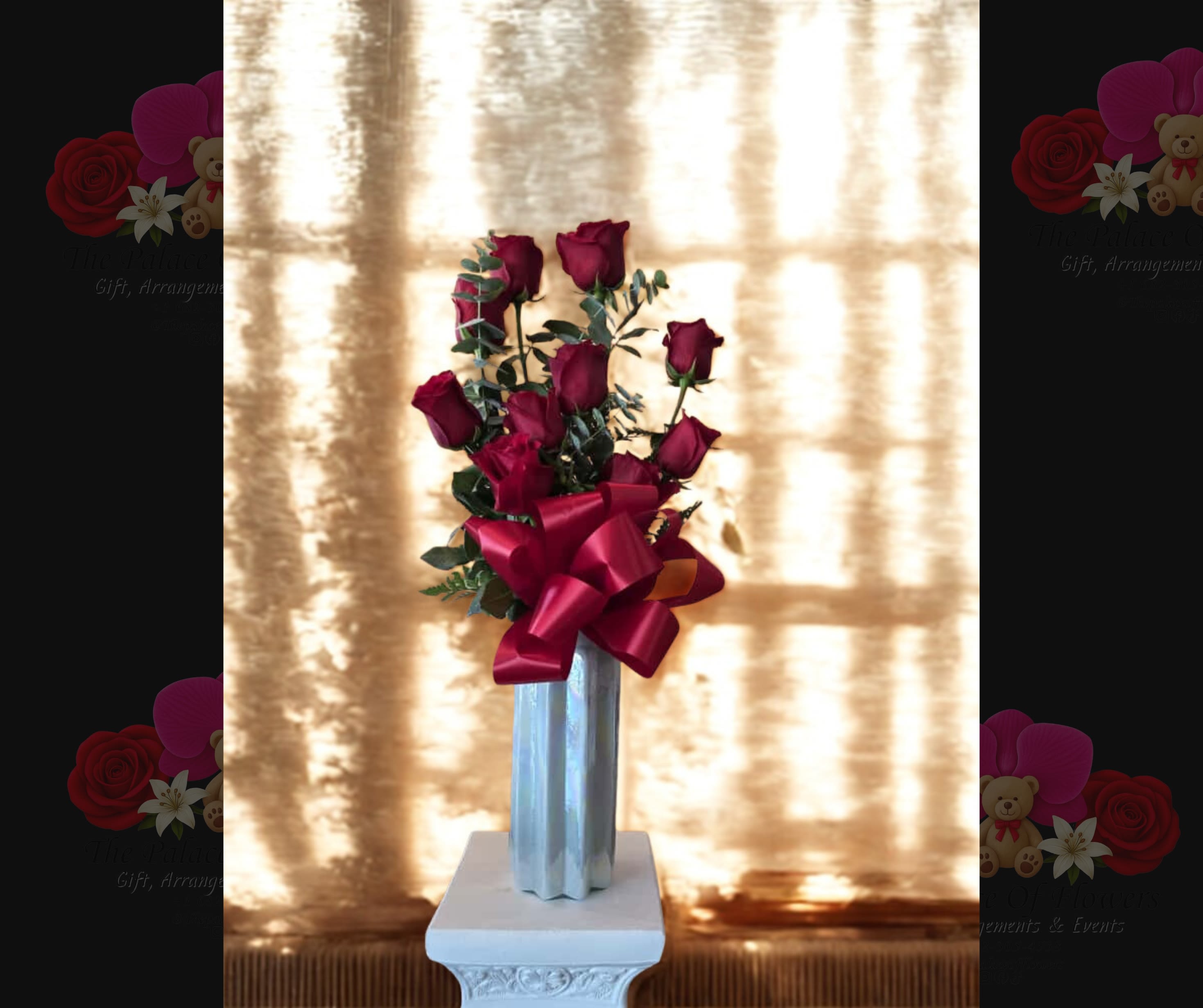 Tall bouquet of red roses in a silver vase with a large red ribbon