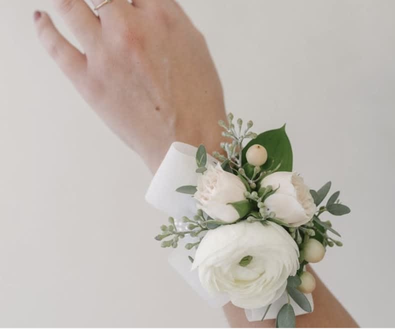 White and blush wrist corsage with round white bloom and buds on a white band