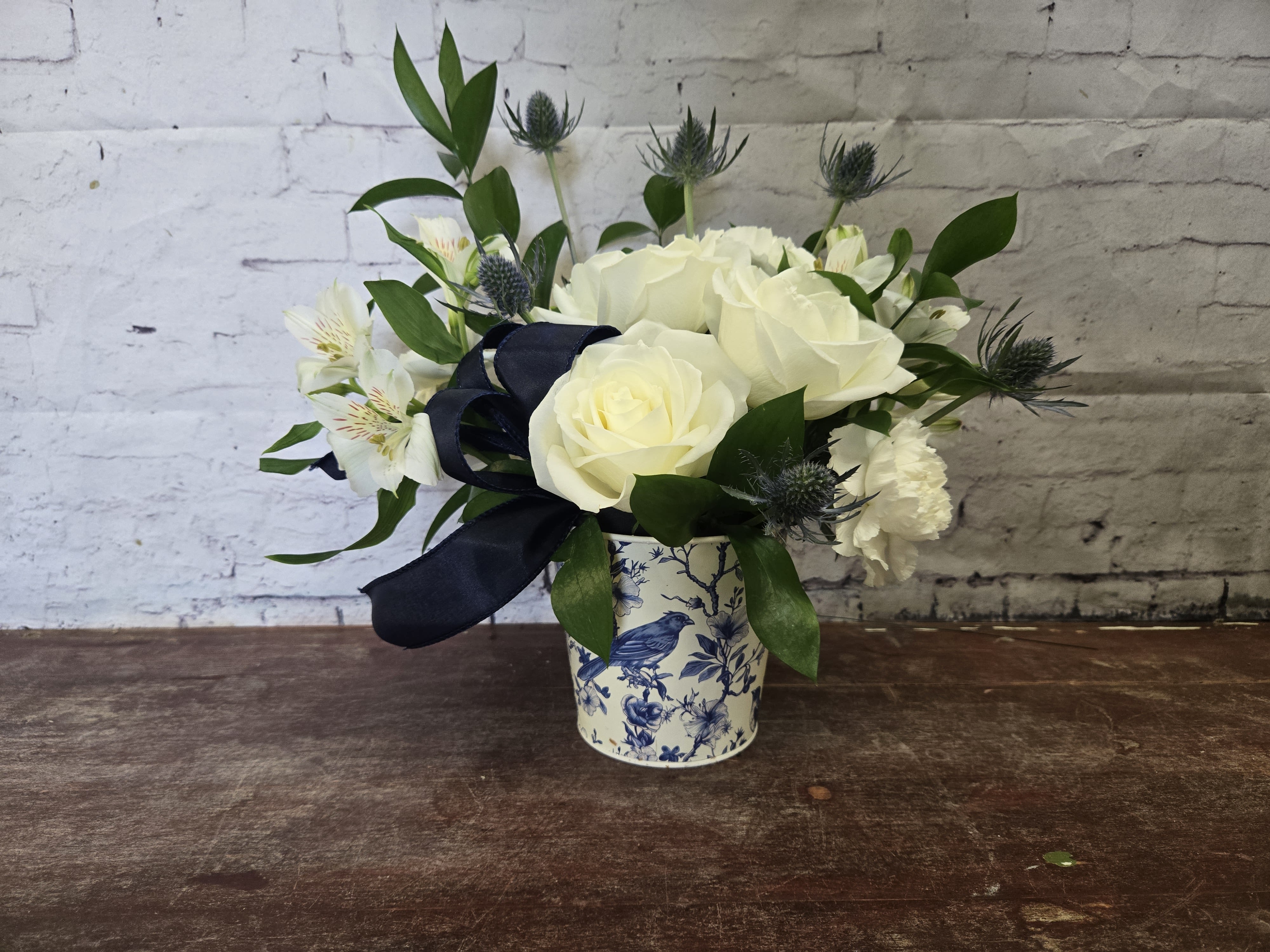 Regal - Beautiful white Arrangement with a touch of blue.