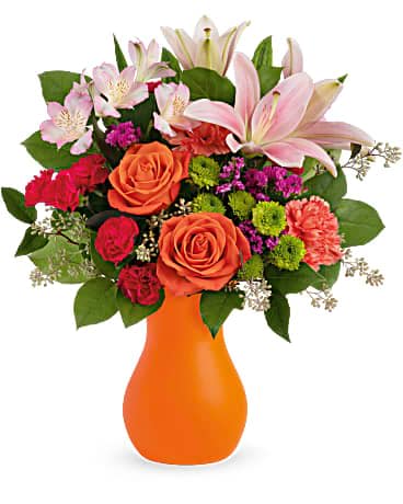 Mixed bouquet of roses, lilies, and carnations in an orange vase