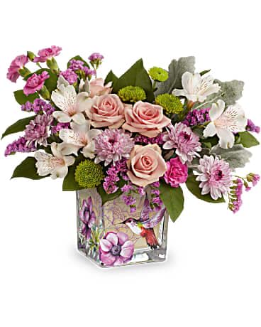 Pink roses and white flowers in a square glass vase with floral artwork