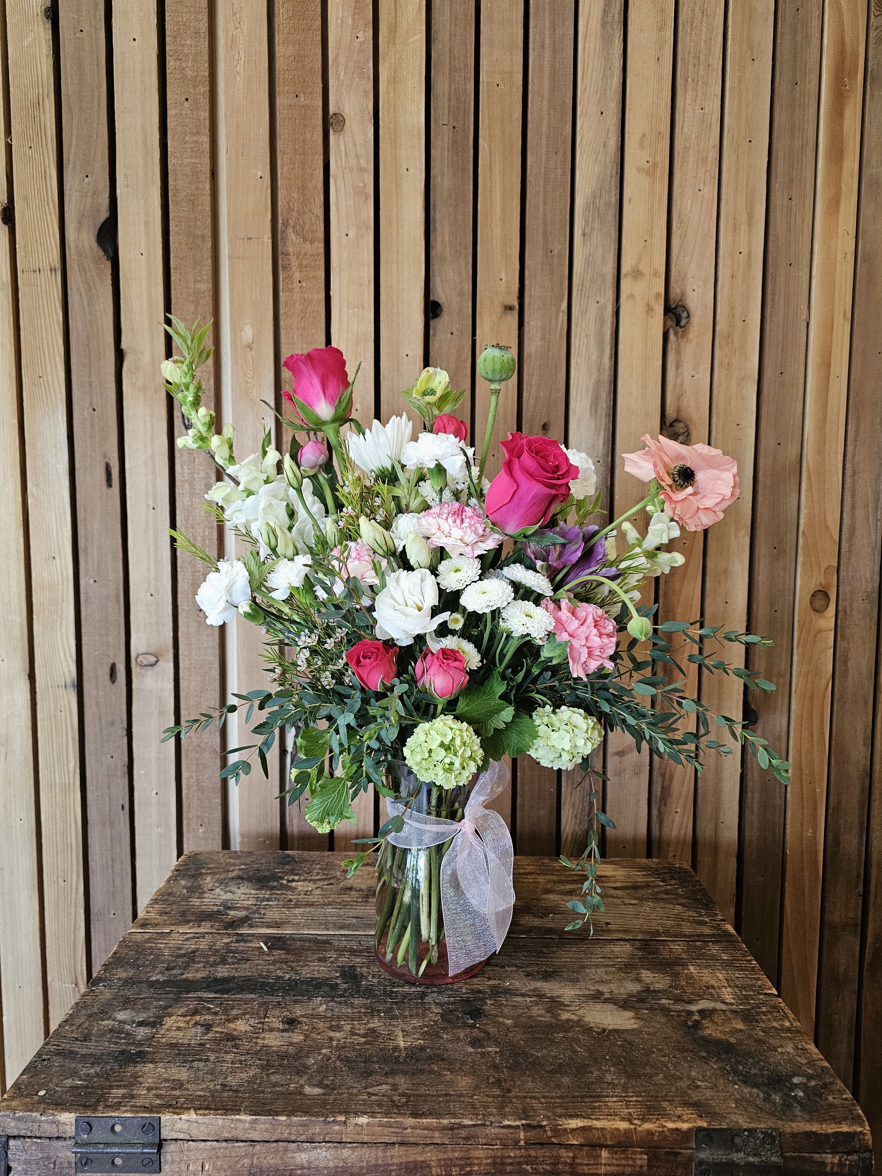 Rosewater Garden - Layers of pink, white, and lavender blooms with touches of bright pink, styled in a pink vase for a romantic, airy composition.