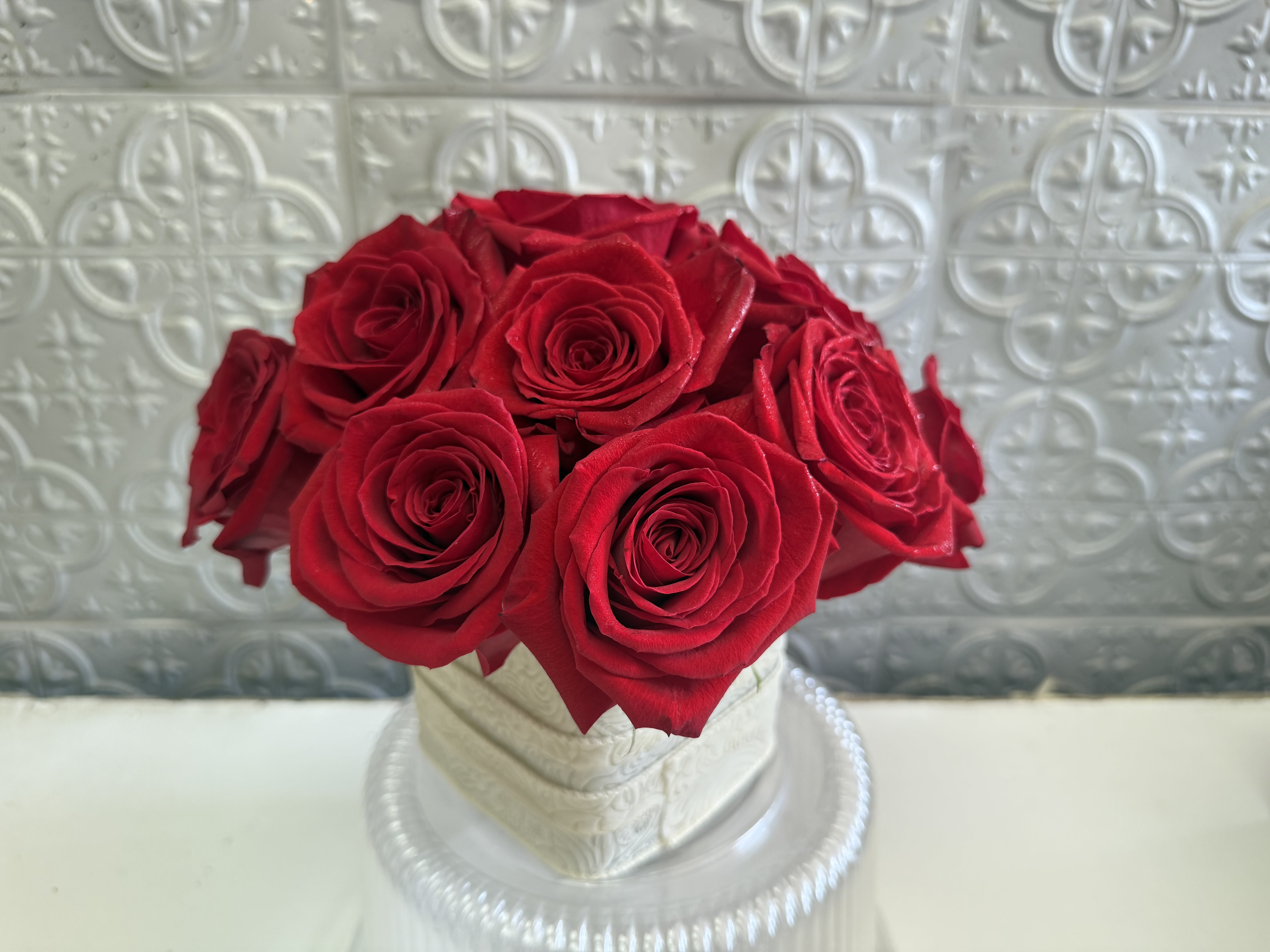 Red roses arranged in a white hatbox