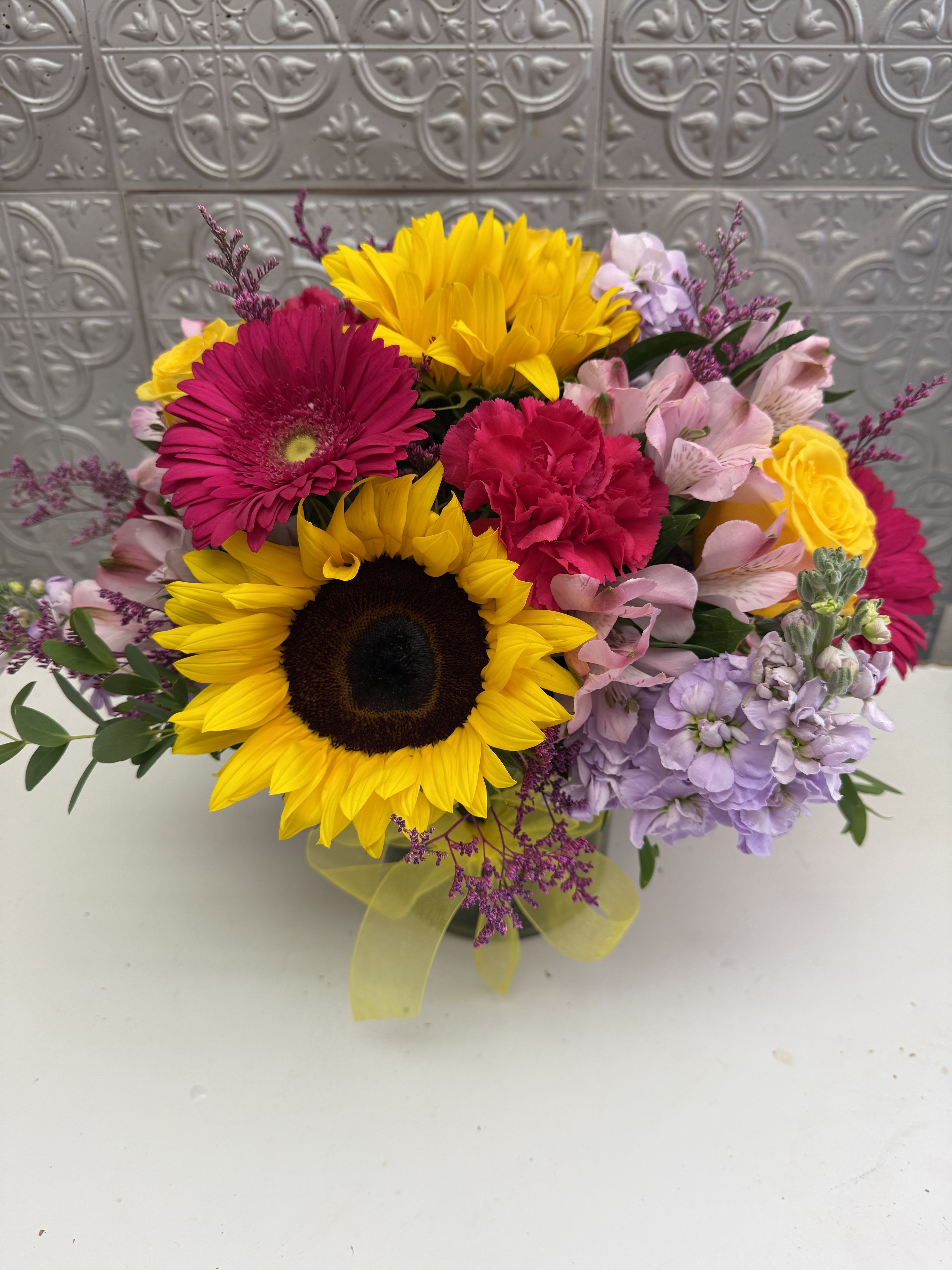Mixed bouquet with sunflowers, pink gerberas, and pastel blooms