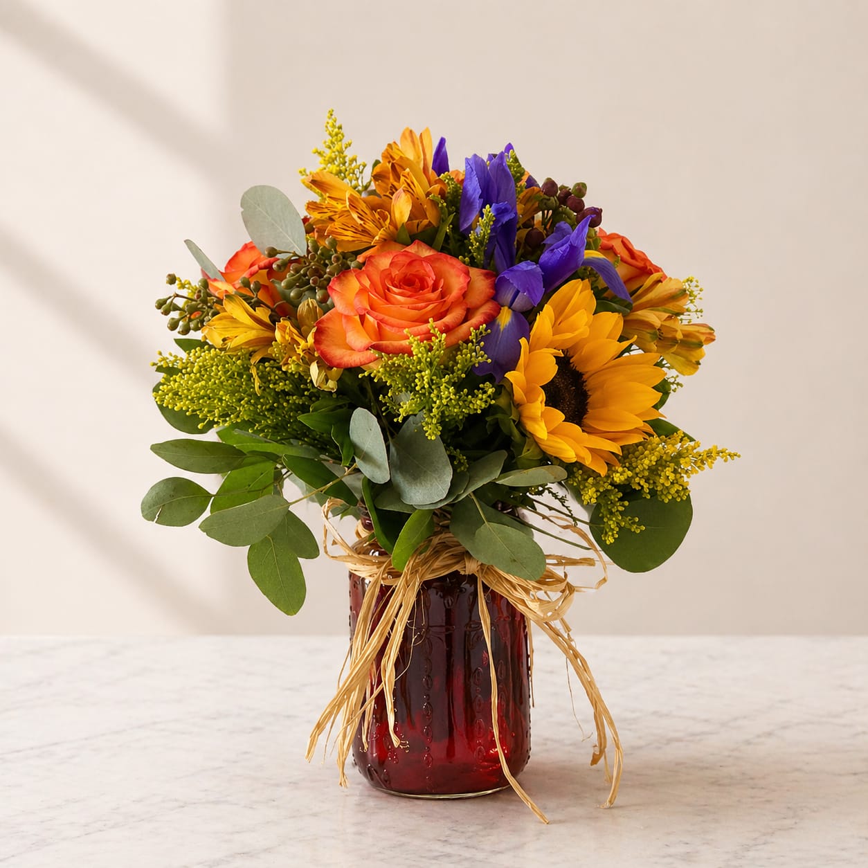 A Summer Kiss - A Summer Kiss – Brighten Their Day with Sunflowers, Roses &amp; Seasonal Blooms  Bring pure sunshine and happiness into any space with A Summer Kiss, a vibrant floral arrangement designed to warm hearts and lift spirits. This stunning bouquet features radiant golden sunflowers, lush orange roses, and a delightful mix of seasonal blooms, all artfully arranged in a charming mason jar vase. Perfect for birthdays, celebrations, thank-you gifts, or just because, its cheerful colors and fresh, summery vibe make it an unforgettable surprise for loved ones. Hand-crafted for maximum beauty, A Summer Kiss is the perfect way to send joy, love, and a splash of summer to someone special.