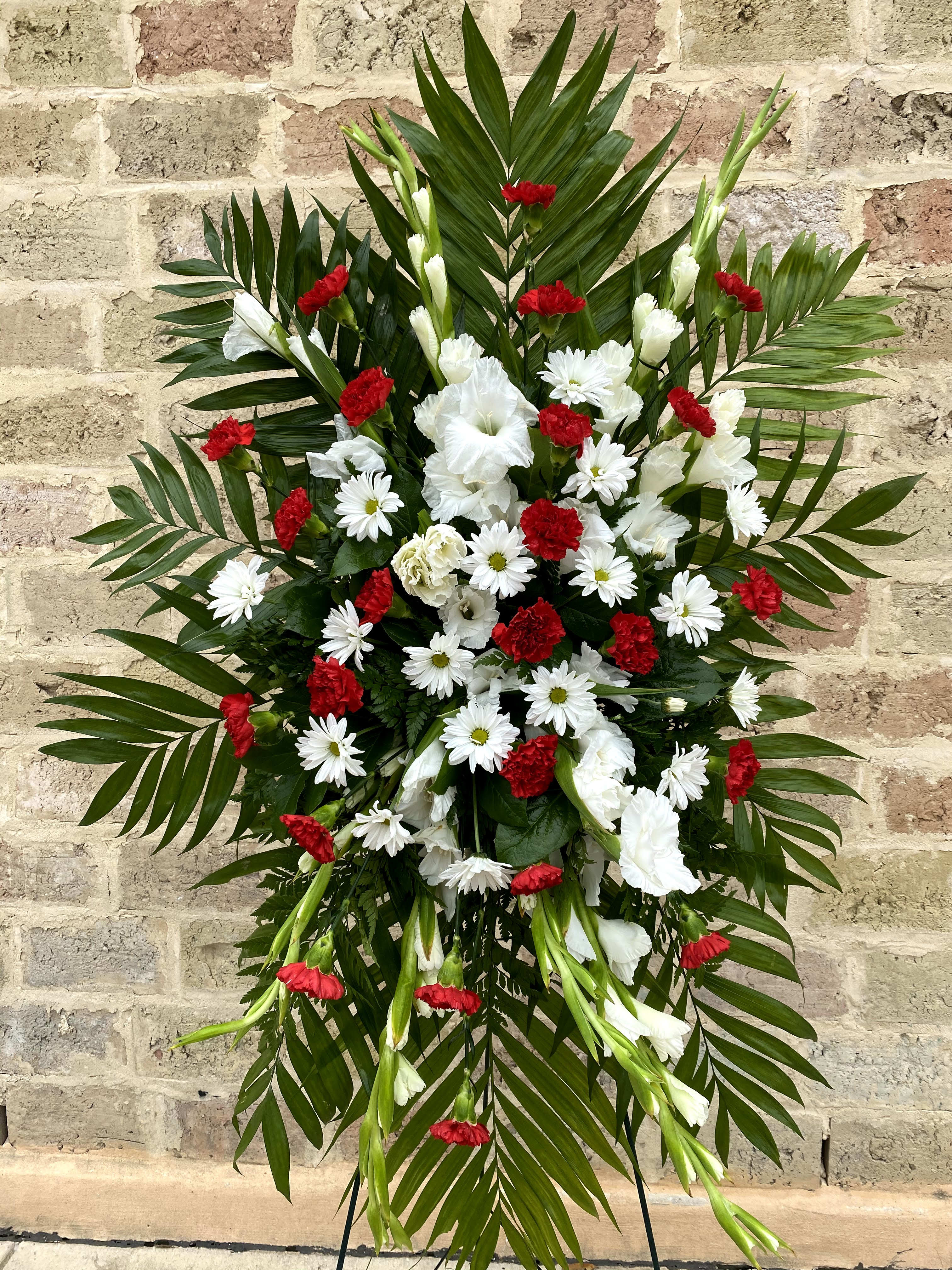 Standing floral spray with red and white flowers and palm fronds