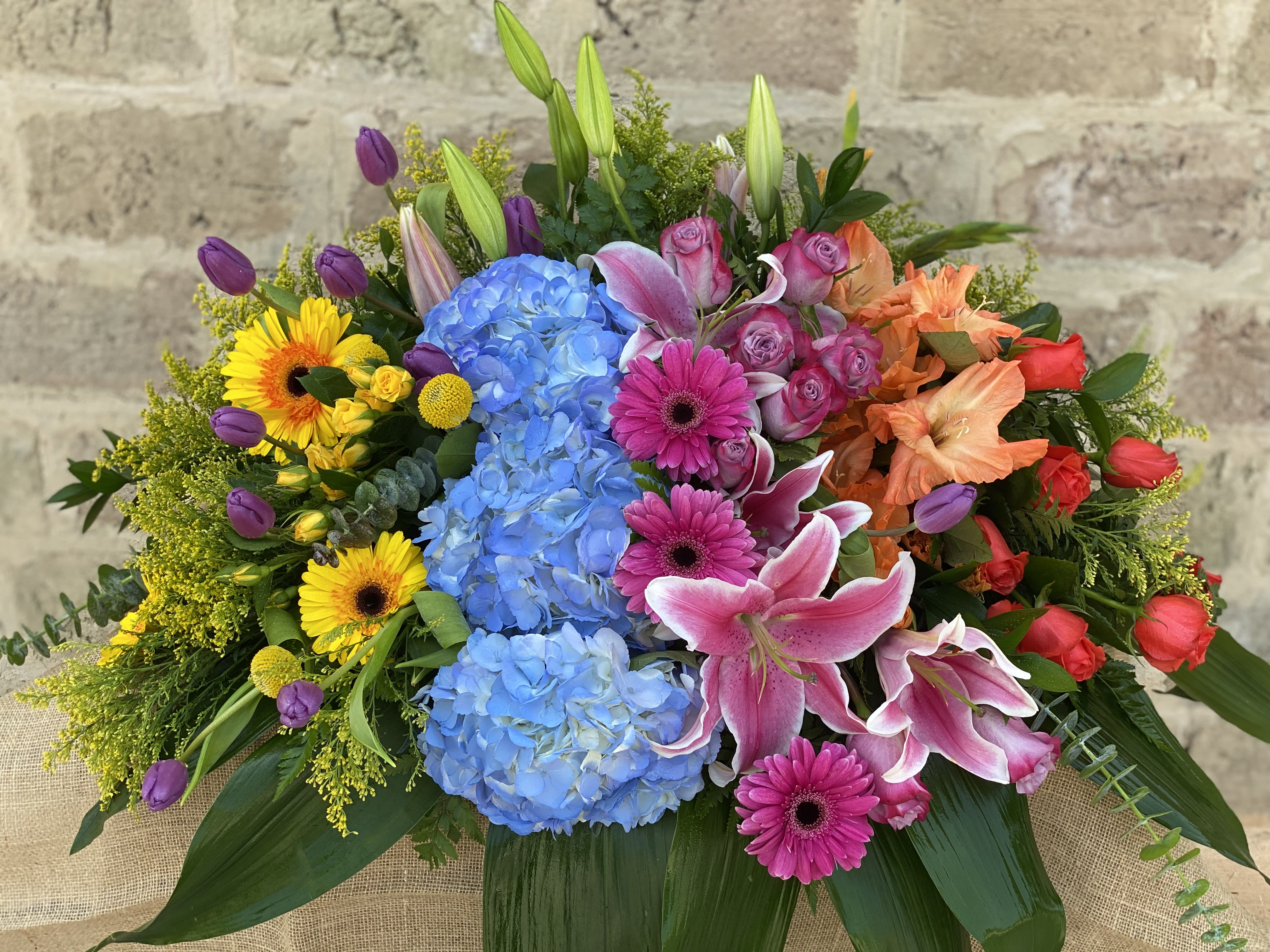 Colorful mixed bouquet with blue hydrangeas, pink lilies, and roses