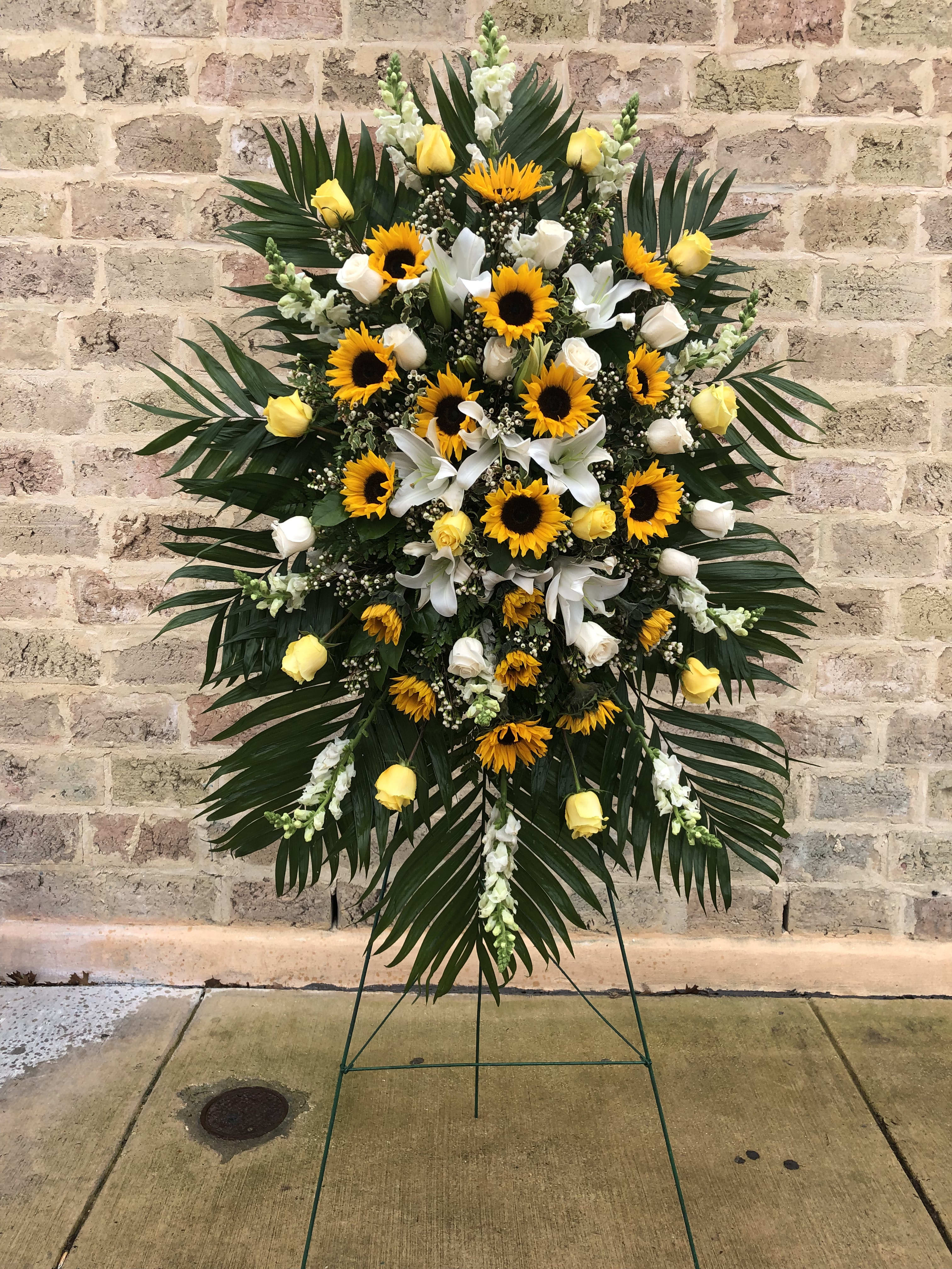 Standing floral spray with sunflowers, yellow roses, and white lilies