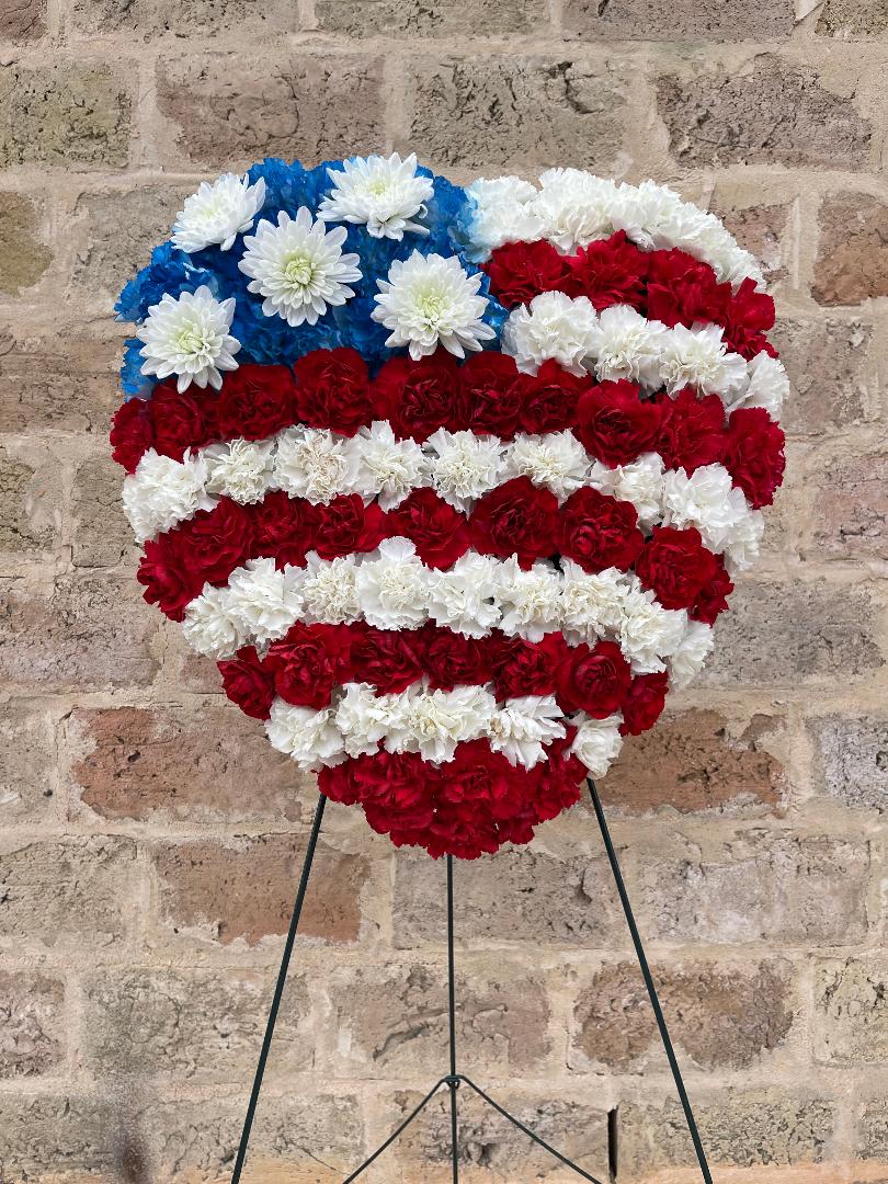 Patriotic Heart Standing Spray - Red, white and blue carnations in the shape of a heart, symbolizing the American flag, create a patriotic display that will celebrate devotion and service to one’s country. A lovely tribute to a veteran or member of the United States armed forces.