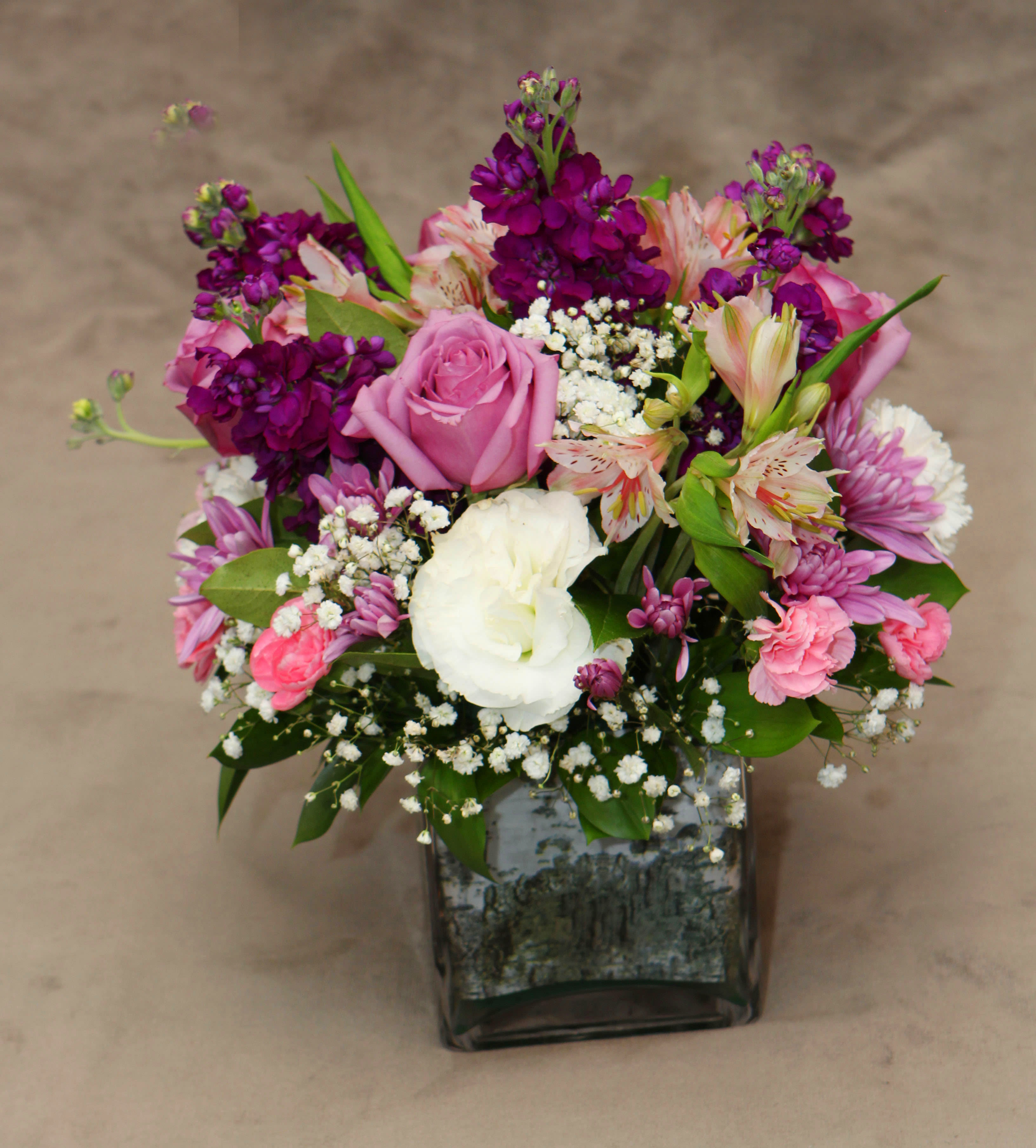 Cool Waters  - A lovely combination of lavender roses, pink mini carnations, purple stock, alstromeria, and lavender cushion mums. Making this a delicate and feminine touch. 