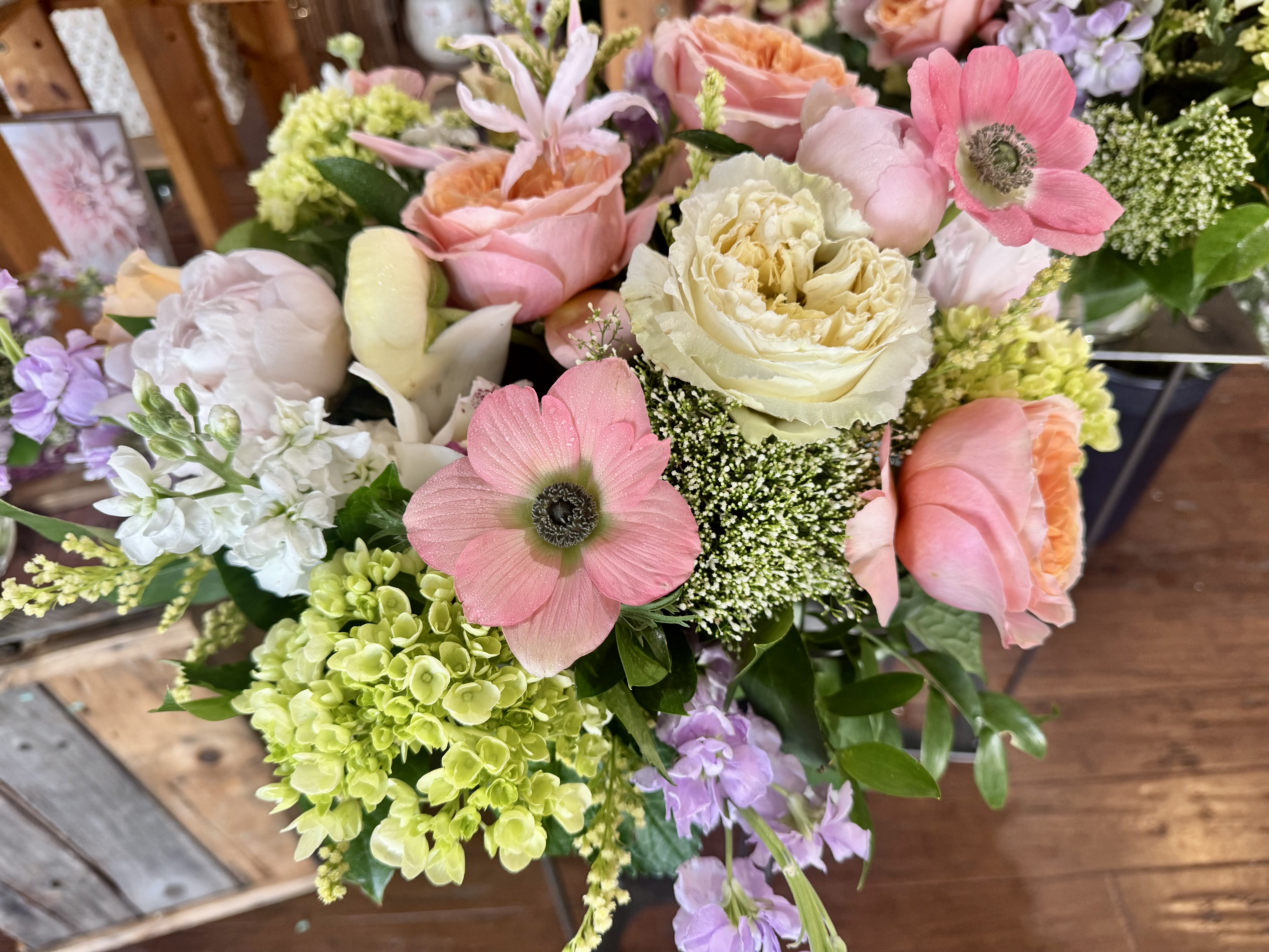 * Mother's Day Mix* - A lush, garden-inspired bouquet.  Clustered hydrangeas add fullness and a soft, cloud-like texture, complemented by delicate stock and airy filler blooms that lend movement and scent. The color story-pink, white, purple, and green-works beautifully for moms, friends, or anyone who loves a soft, elegant palette. Sized to sit proudly on a dining table or bedside, the bouquet arrives ready to display; refresh water daily and recut stems when you change the vase to keep the blooms at their best.