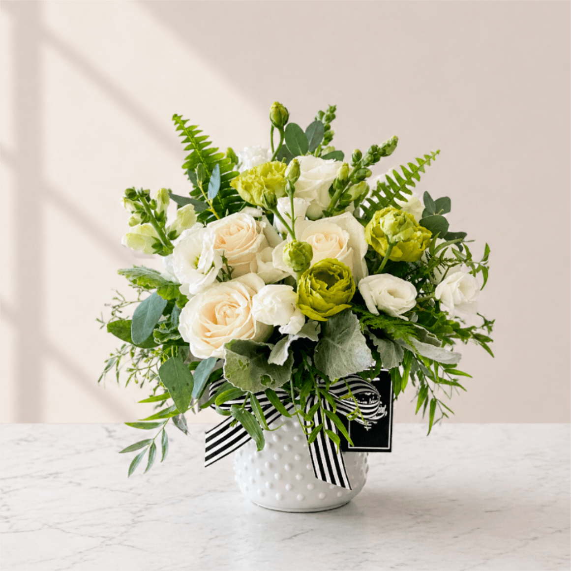 Splendid &amp; Sweet - Are you looking for a special way to brighten someone's special day? Then treat them to Splendid and Sweet, a wonderful arrangement perfect for all occasions! Our eye-catching arrangement contains white and green lisianthus and white spray roses in a stunning white hobnail vase tied off with an elegant black and white stripe ribbon. 
