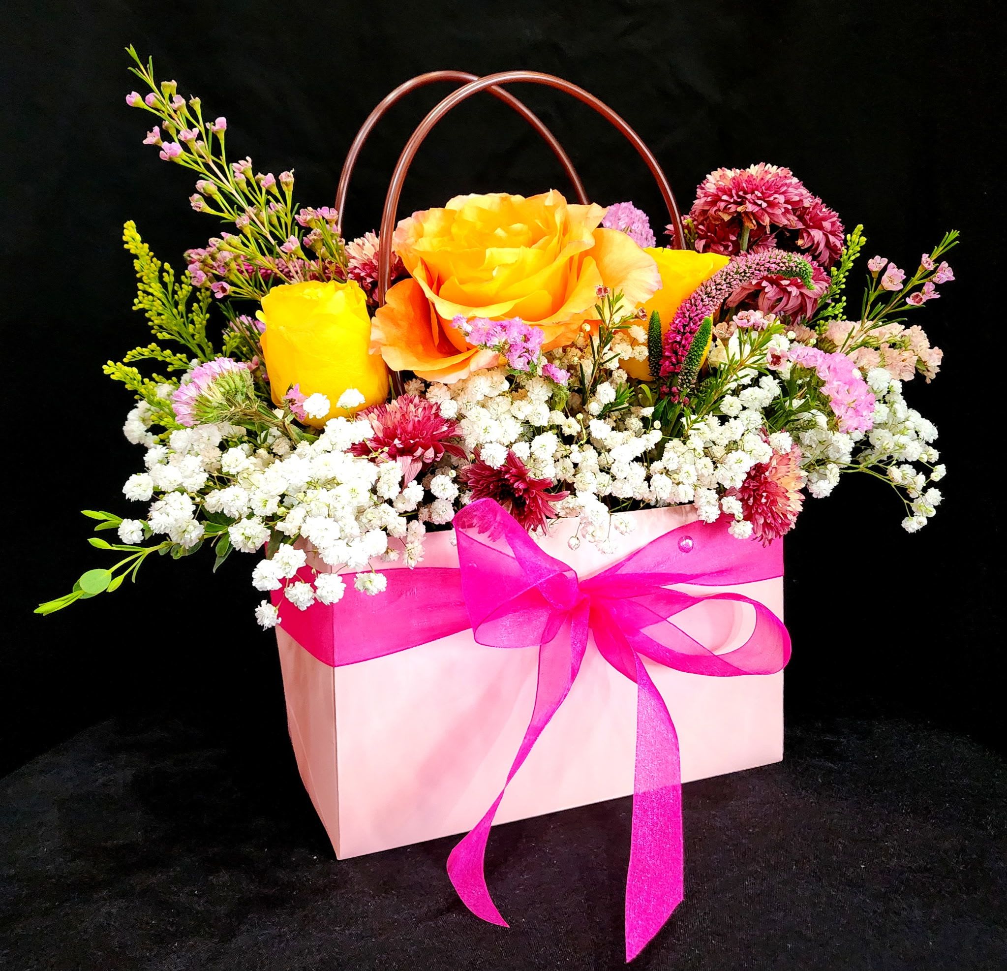 For Mom with Love  - Surprise your mom with this beautiful tote inspired arrangement with gorgeous flowers to make her feel special. This arrangement includes roses, chrysanthemums, wax flowers, veronicas, solidago, babies breath and eucalyptus.  You may also request different colors of roses and choose between 3 colors, pink, black, or white, just be sure to mention which color in special instructions.   Dimensions are approximately: Tote is 13" Height x 8" Length x 4 1/2" Depth. Size with flowers: 11" Height x 10" Length. 