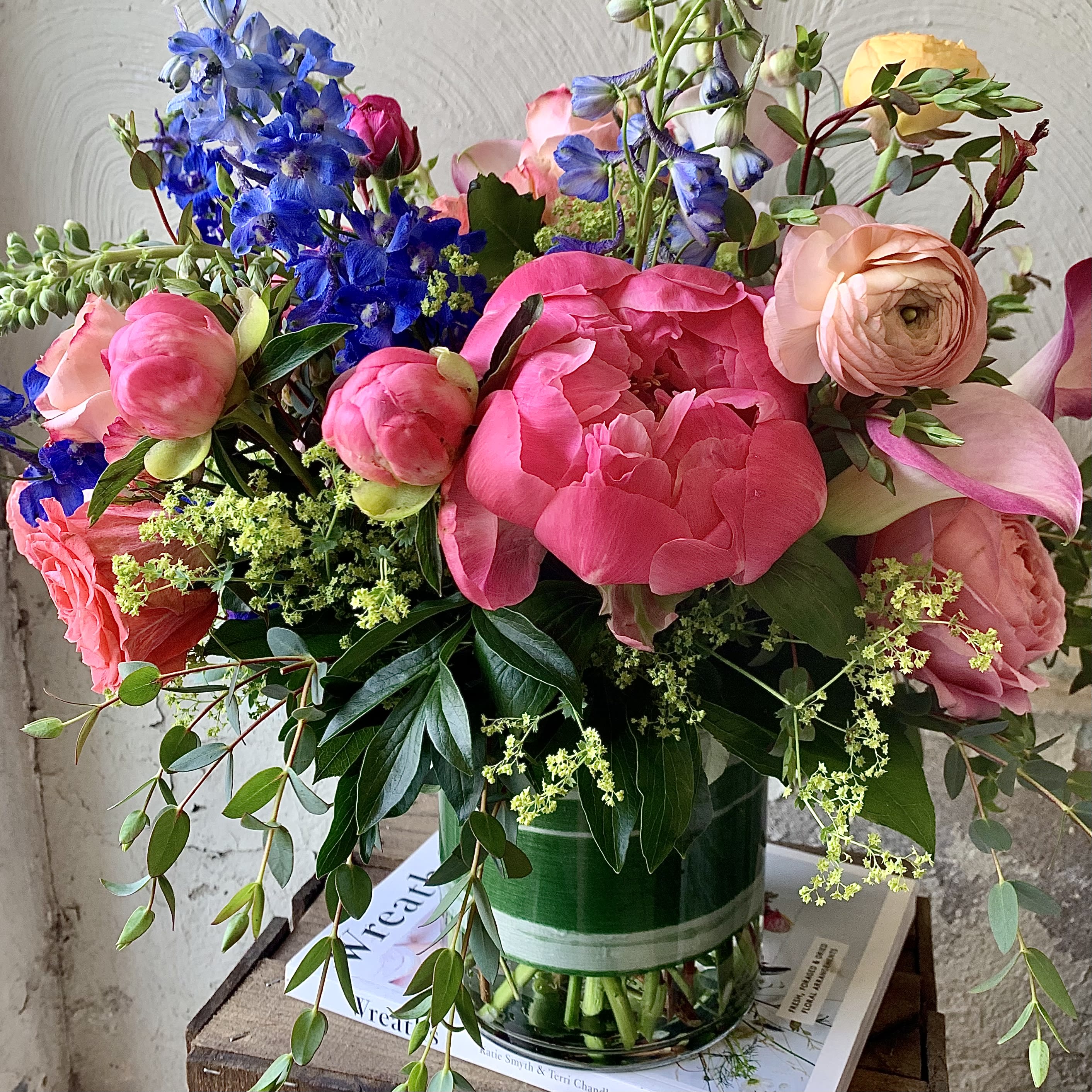 Celebration  - Celebrate MOM with this bright arrangement! Blue delphinium, coral peonies and ranunculus are sure to WOW!