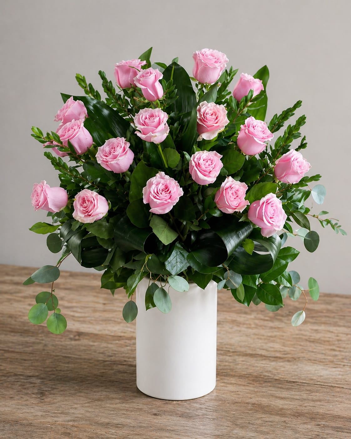     Rosé Grace - A timeless and elegant arrangement of soft pink roses, thoughtfully designed in a modern white cylinder vase and accented with lush greenery. This piece captures the beauty, warmth, and gentle love we feel for every Mom 