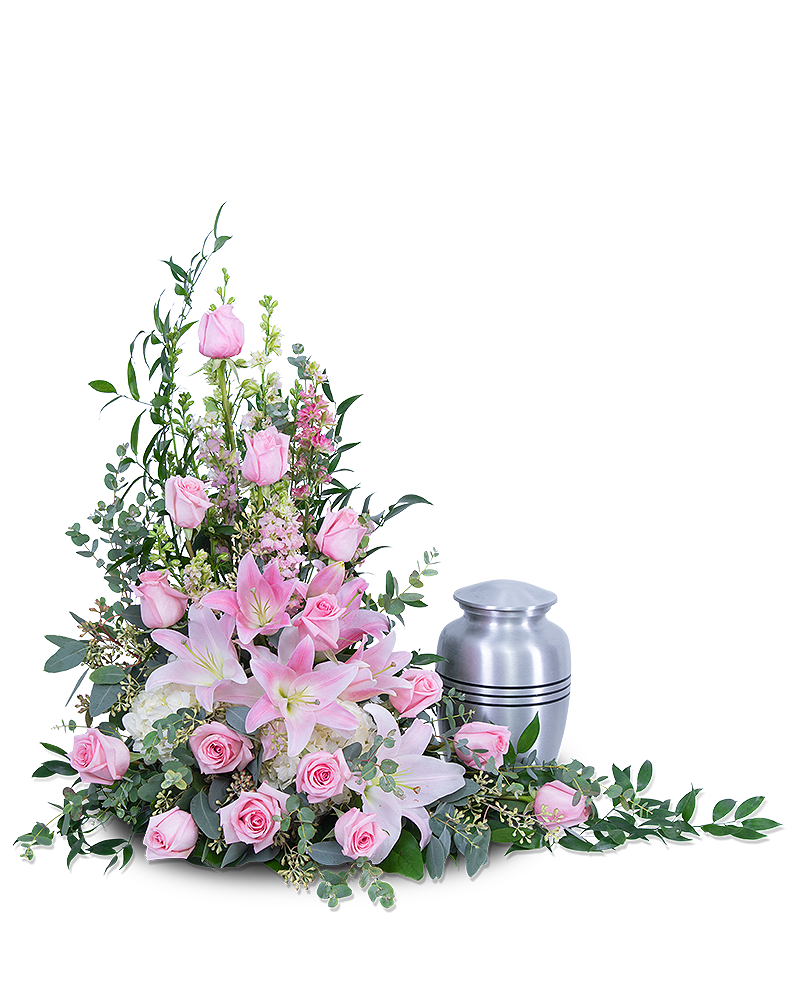 Pink roses and lilies arranged beside a silver urn
